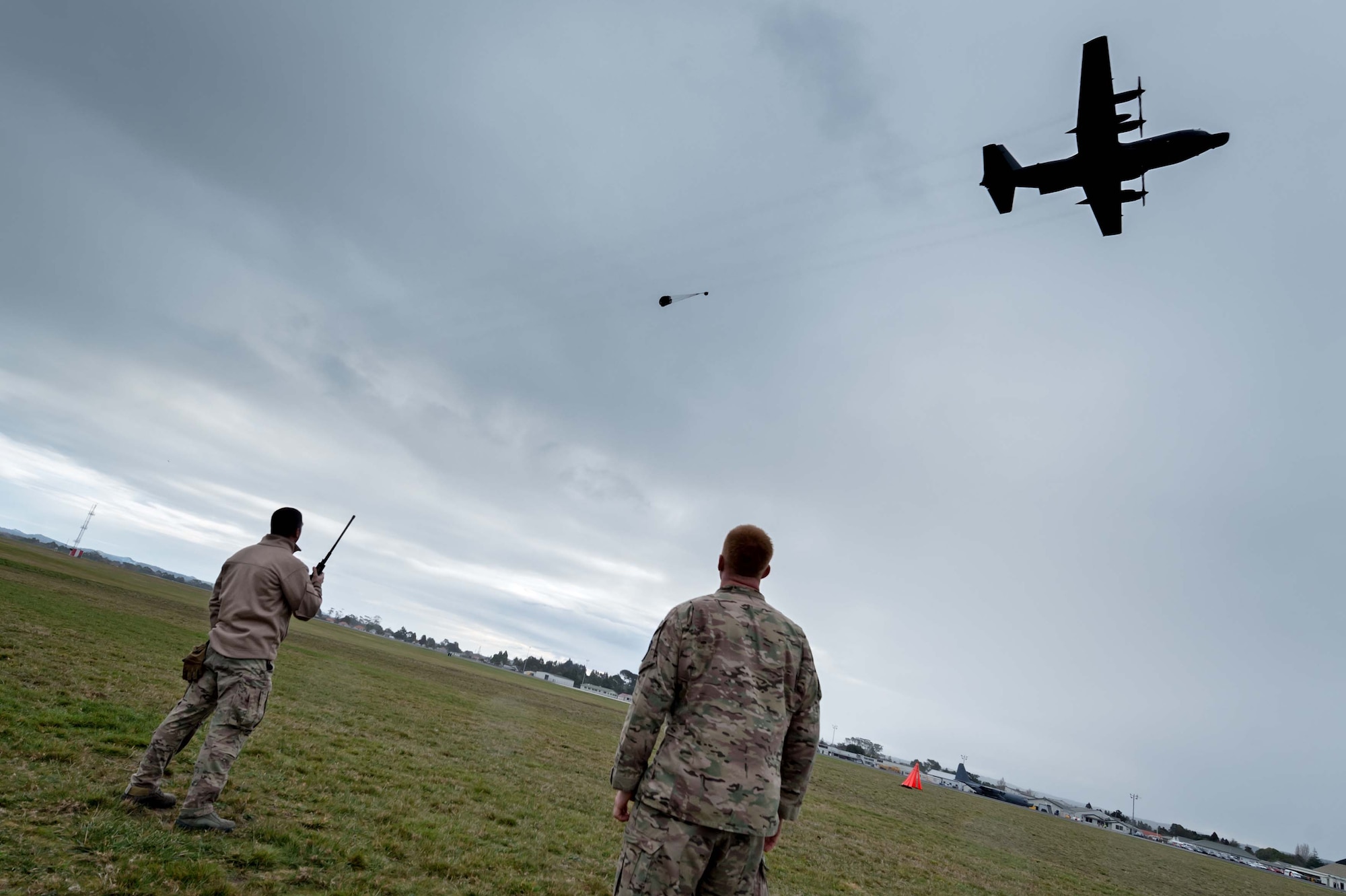 From left, Tech. Sgt. Ryan Gossen, 1st Special Operations Squadron, and Staff Sgt. Cody Medsker, 353rd Special Operations Support Squadron, observe as an aircrew from the 1st Special Operations Squadron conduct an airdrop July 29, 2014 from an MC-130H Combat Talon II over a drop zone in New Zealand during Exercise Balance Net.  Members from the 353rd Special Operations Group and the New Zealand Defense Forces worked together to build, rig and inspect cargo for air drop during the Exercise Balance Net July 17-31.  (New Zealand Defense Force Photo by Roderick MacKenzie)        