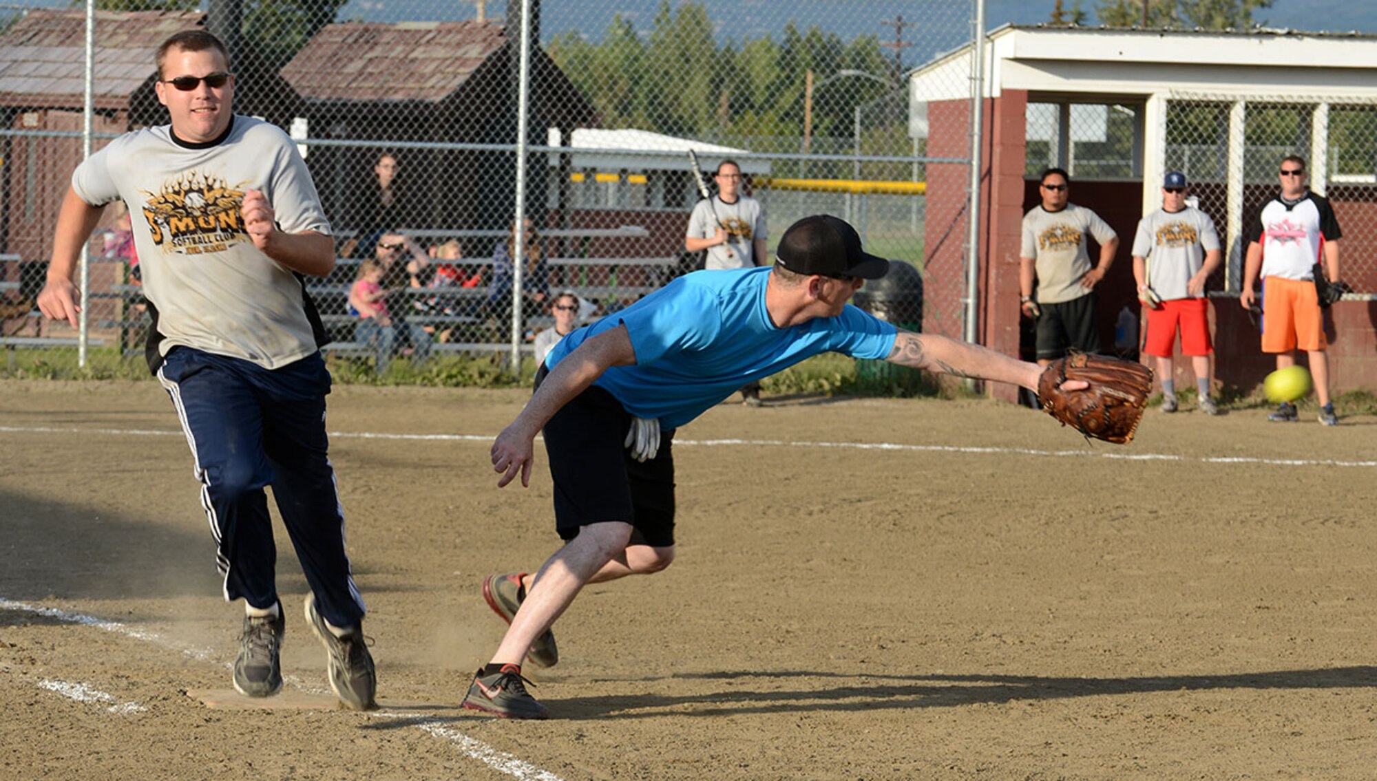 Phillip Kersey, 3rd Aircraft Maintenance Squadron, prepares to catch a ball at first base as James Keen, 3rd Munitions Squadron, tries to beat the throw during the first of two games to decide the JBER softball league championship at Buckner Field August 21. The 3rd MUNS team defeated the team from the 3rd AMXS to capture the title. (U.S. Air Force photos/Staff Sgt. Blake Mize)