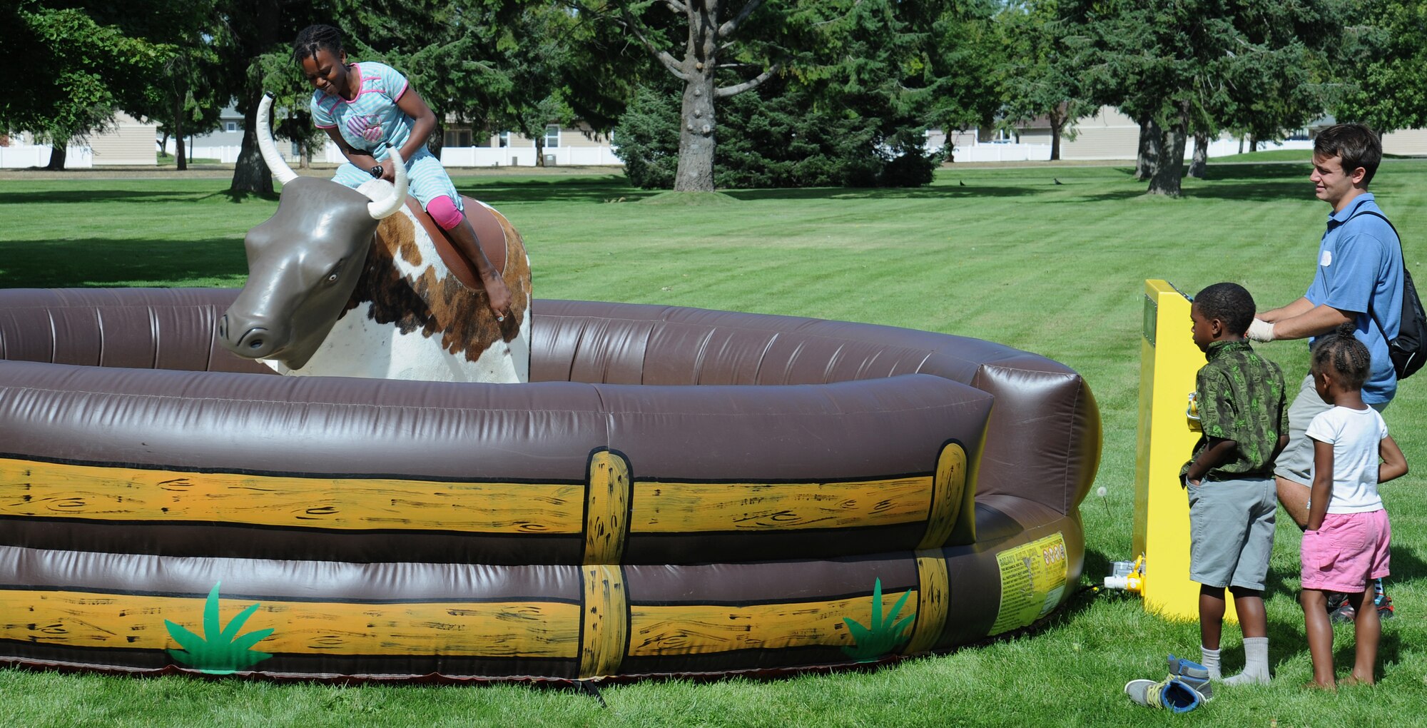 Fairchild families had an opportunity to ride a mechanical bull during the End of Summer Bash in Miller Park at Fairchild Air Force Base, Washington, Aug. 28, 2014. The party, hosted by the 92nd Force Support Squadron, included food, games, laser tag, pony rides, a giant trike race, live entertainment and inflatables for all ages. (U.S. Air Force photo by Staff Sgt. Samantha Krolikowski/Released)