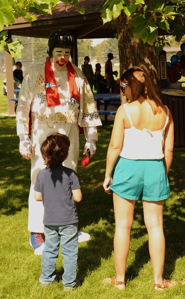 Fairchild families interact with an Elvis clown during the End of Summer Bash in Miller Park at Fairchild Air Force base, Washington, Aug. 28, 2014. The party, hosted by the 92nd Force Support Squadron, included food, games, laser tag, pony rides, a mechanical bull, live entertainment and inflatables for all ages. (U.S. Air Force photo by Staff Sgt. Samantha Krolikowski/Released)