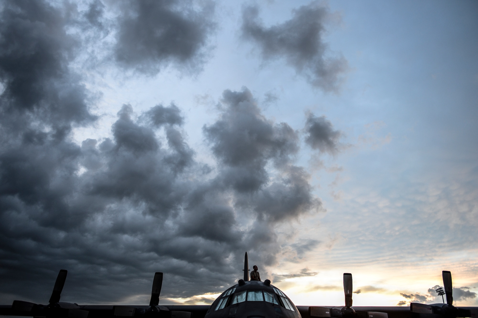 Staff Sgt. Patrick Glenn, a 314th Aircraft Maintenance Squadron crew chief, takes a moment to enjoy the sunrise Aug. 18, 2014, at Little Rock Air Force Base, Ark. Little Rock AFB is home to the largest C-130 fleet in the world, and is comprised of approximately 80 aircraft. (U.S. Air Force photo by Airman 1st Class Cliffton Dolezal)
