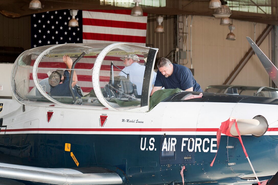 Toby Pfannenstiel, Kenneth Calpito and Roger Jackson, base contractors for the 80th Training Wing, perform maintenance on a T-6A Texan II at Sheppard Air Force Base Aug. 26, 2014. The T-6A Texan II is a single-engine, two-seat primary trainer designed to train student pilots in the Euro-NATO Joint Jet Pilot Training program. (U.S. Air Force Photo by Danny Webb/Released)