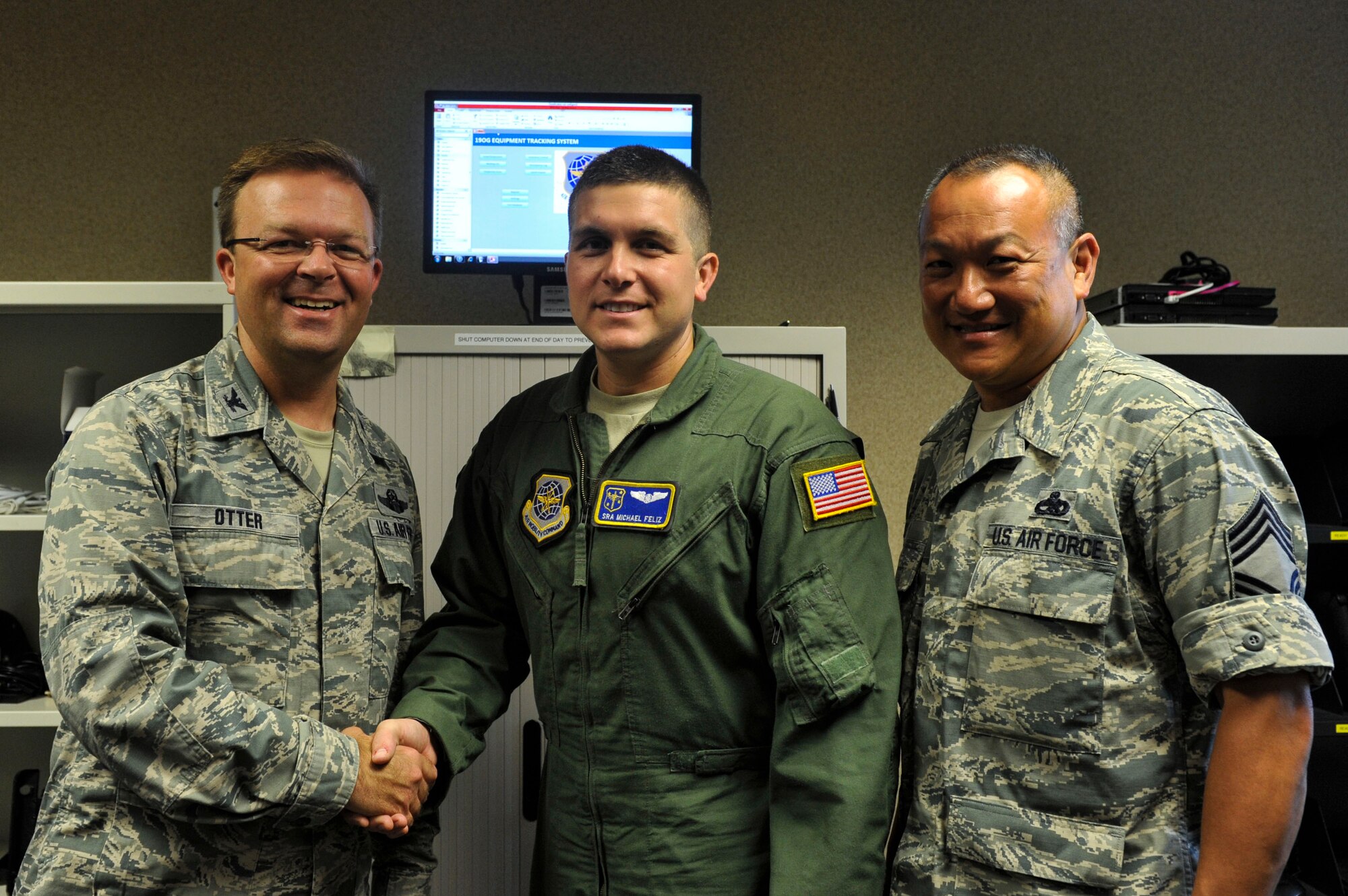 Col. William Otter, 19th Aillift Wing vice commander, along with Chief Master Sgt. Jimmy Ku, 19th Maintenance Group command chief, congratulate Senior Airman Michael Feliz, a 19 th Operations Group publications officer and C-130J loadmaster, for his selection as Combat Airlifter of the Week Aug. 25, 2014, at Little Rock Air Force Base, Ark. Feliz, a Panama City, Fla., native is in charge of the distribution and oversight of two Mission Design Series publications shops and 11 personnel, providing Technical Order changes and updates to more than 800 crewmembers.  (U.S. Air Force photo by Senior Airman Regina Agoha)  
