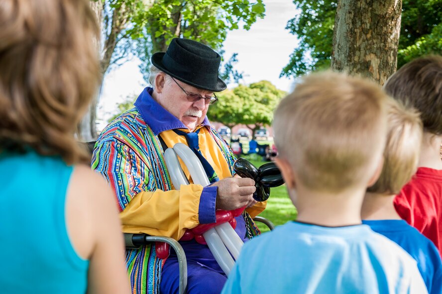 Fairchild youth watch as a concessionaire twists balloons into different shapes and animals for them during the End of Summer Bash in Miller Park at Fairchild Air Force Base, Washington, Aug. 28, 2014. The party, hosted by the 92nd Force Support Squadron, included food, games, laser tag, pony rides, a giant trike race, live entertainment and inflatables for all ages. (U.S. Air Force photo by Staff Sgt. Benjamin W. Stratton/Released)