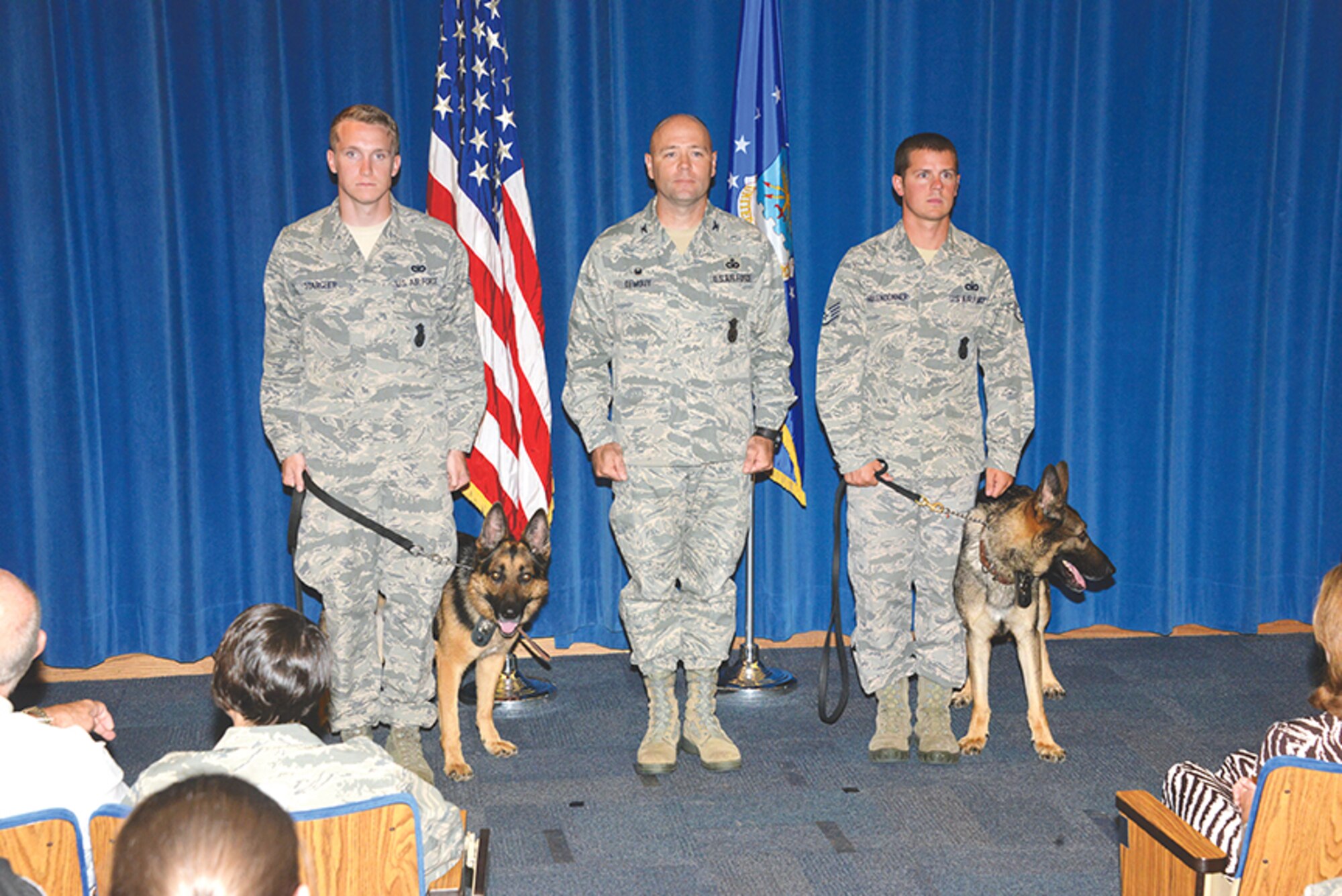 Col. Richard DeMouy, center, commander of Kirtland’s 377th Security Forces Group, presides over the retirement ceremony for military working dogs Dan and Joeri. DeMouy is flanked by dog handlers Staff Sgt. John Starcher (left), 377th Weapons System Security Squadron, and Staff Sgt. William Hollendonner, 377th SFG. (Photo by Dennis Carlson) 