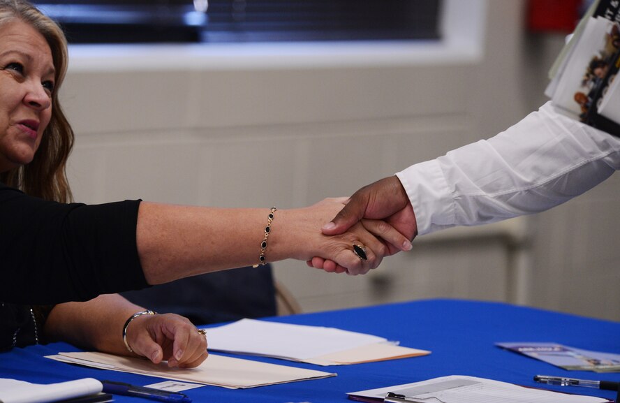 Rebekah Kruszeski, Lowes human resource manager, shakes the hand of a Team Shaw member after discussing possible employment opportunities at the job fair at Shaw Air Force Base, S.C., Aug. 28, 2014. Approximately 100 members of Team Shaw and 20 employers from the local area attended the job fair. (U.S. Air Force photo by Senior Airman Tabatha Zarrella/Released) 