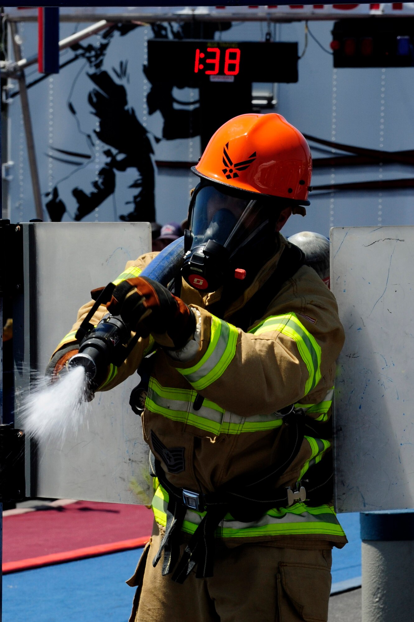 Tech. Sgt. Joe Absher, 30th Civil Engineering Squadron firefighter, douses a replicated fire while competing in the Scott Firefighter Combat Challenge, Aug. 22, 2014, Ontario, Calif. The challenge began as a university-based research study and has since evolved into a five-event obstacle course simulating the physical rigors of structural firefighting. (U.S. Air Force photo by Senior Airman Shane Phipps/Released)