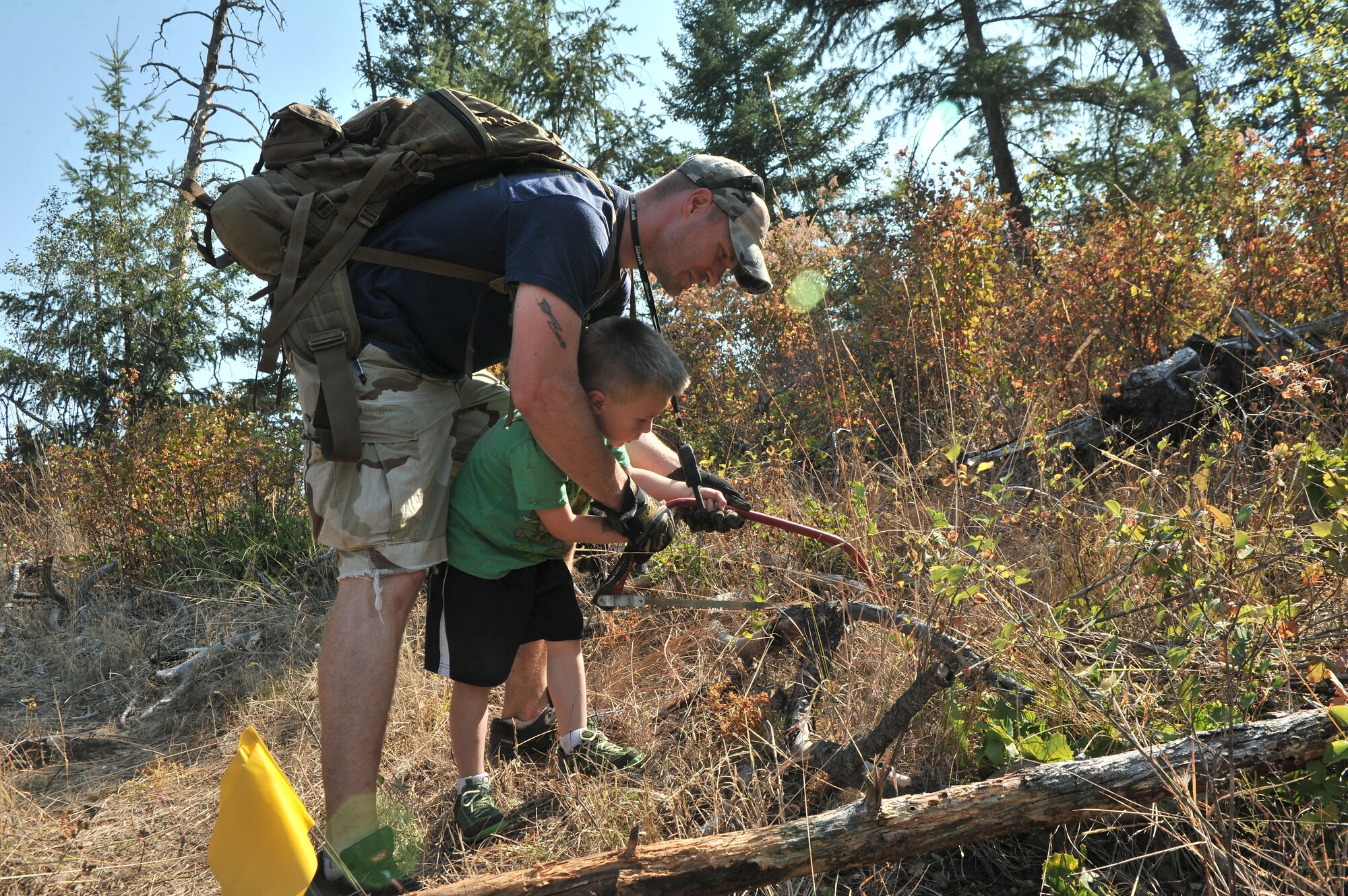 Airmen from the 22nd Training Squadron clear trail paths with family and friends as part of their resiliency and team-building activity on Tubbs Hill in Coeur d’Alene, Idaho, August 11, 2014. A team of about 30 volunteers from the 22nd TRS and SERE Solutions Inc., along with family friends, participated in a two day team building and resiliency event that ended with an overnight stay at a local campground, followed by a 15 mile bike ride down the historic Hiawatha Trail in Wallace, Idaho, that crosses the Montana border.  (U.S. Air Force photo by Staff Sgt. Alexandre Montes/Released)
