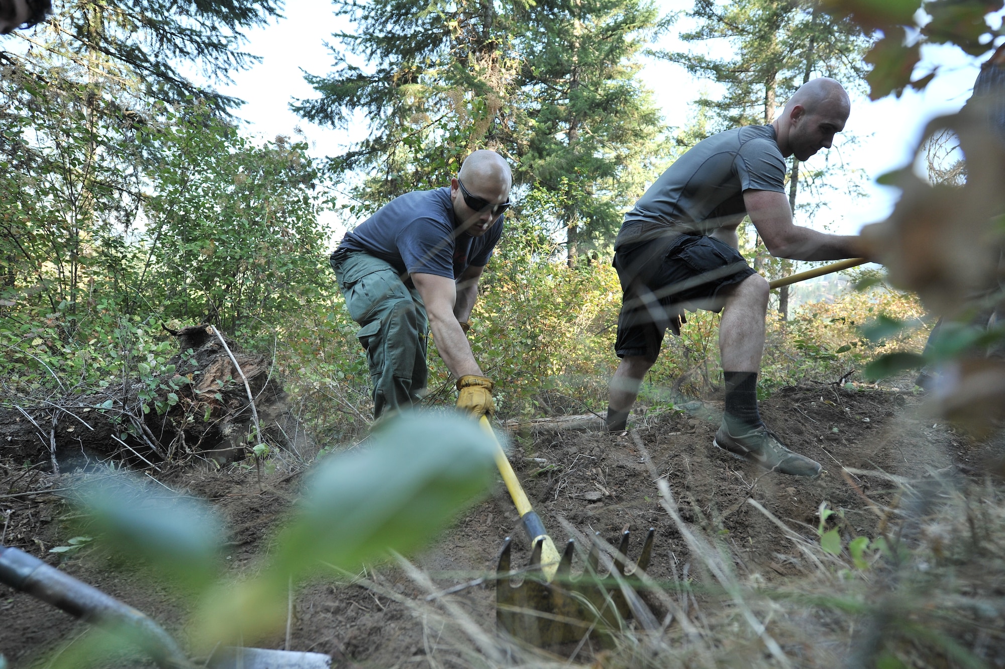 Airmen from the 22nd Training Squadron clear trail paths with family and friends as part of their resiliency and team-building activity on Tubbs Hill in Coeur d’Alene, Idaho, August 11, 2014. A team of about 30 volunteers from the 22nd TRS and SERE Solutions Inc., along with family friends, participated in a two day team building and resiliency event that ended with an overnight stay at a local campground, followed by a 15 mile bike ride down the historic Hiawatha Trail in Wallace, Idaho, that crosses the Montana border.  (U.S. Air Force photo by Staff Sgt. Alexandre Montes/Released)