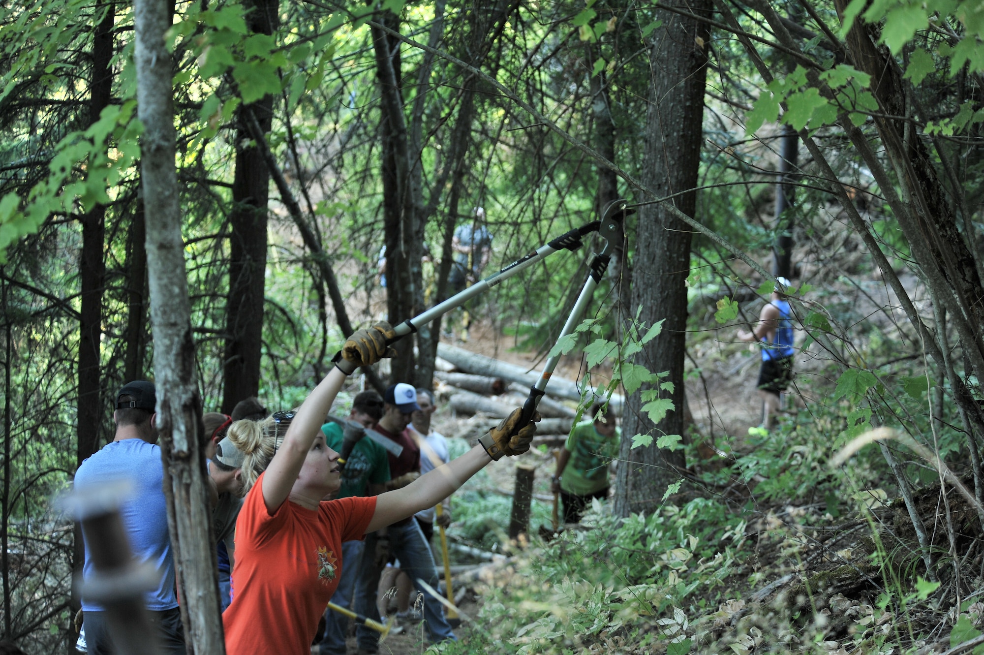 Airmen from the 22nd Training Squadron clear trail paths with family and friends as part of their resiliency and team-building activity on Tubbs Hill in Coeur d’Alene, Idaho, August 11, 2014. A team of about 30 volunteers from the 22nd TRS and SERE Solutions Inc., along with family friends, participated in a two day team building and resiliency event that ended with an overnight stay at a local campground, followed by a 15 mile bike ride down the historic Hiawatha Trail in Wallace, Idaho, that crosses the Montana border.  (U.S. Air Force photo by Staff Sgt. Alexandre Montes/Released)