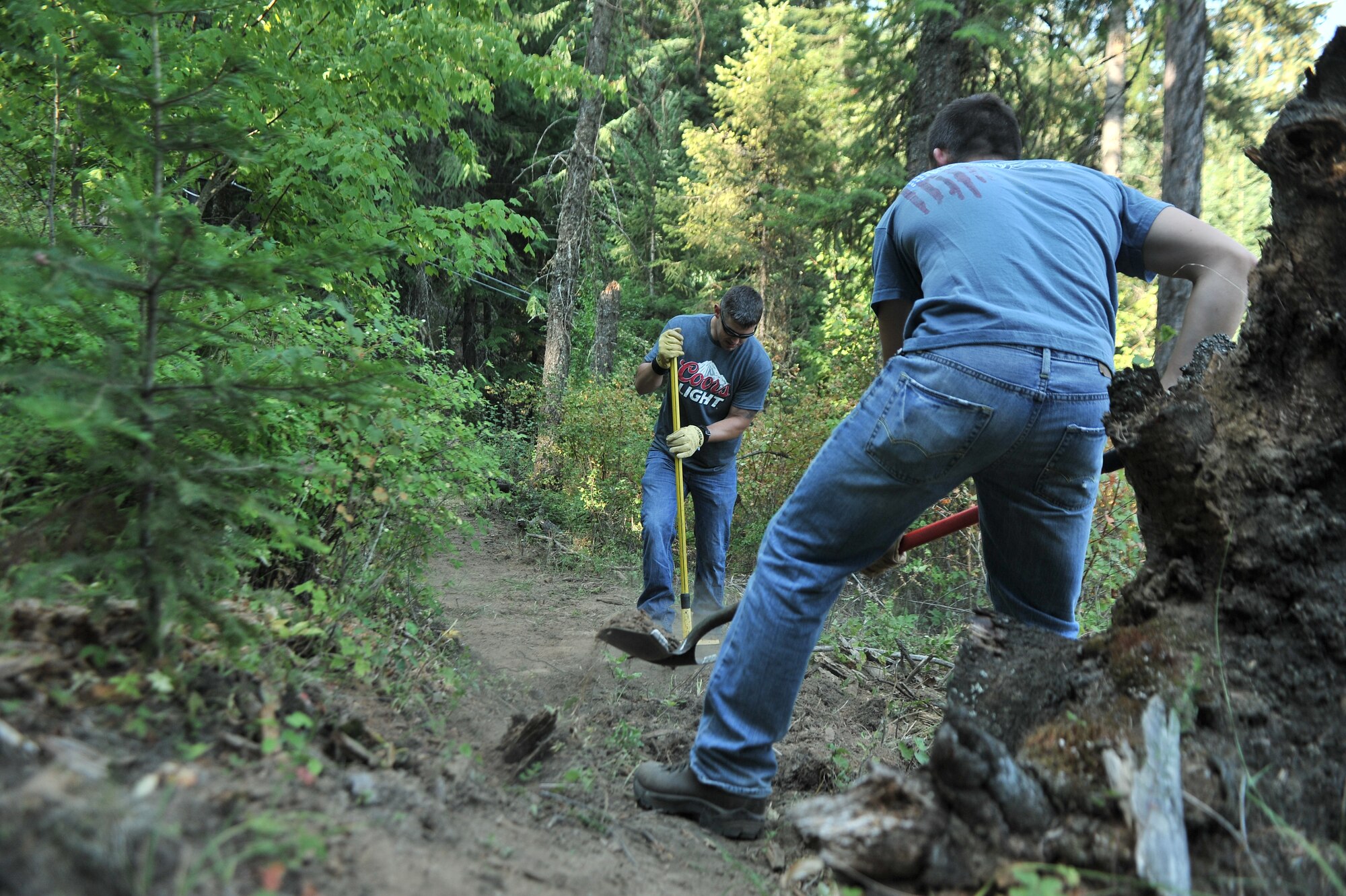 Airmen from the 22nd Training Squadron clear trail paths with family and friends as part of their resiliency and team-building activity on Tubbs Hill in Coeur d’Alene, Idaho, August 11, 2014. A team of about 30 volunteers from the 22nd TRS and SERE Solutions Inc., along with family friends, participated in a two day team building and resiliency event that ended with an overnight stay at a local campground, followed by a 15 mile bike ride down the historic Hiawatha Trail in Wallace, Idaho, that crosses the Montana border.  (U.S. Air Force photo by Staff Sgt. Alexandre Montes/Released)