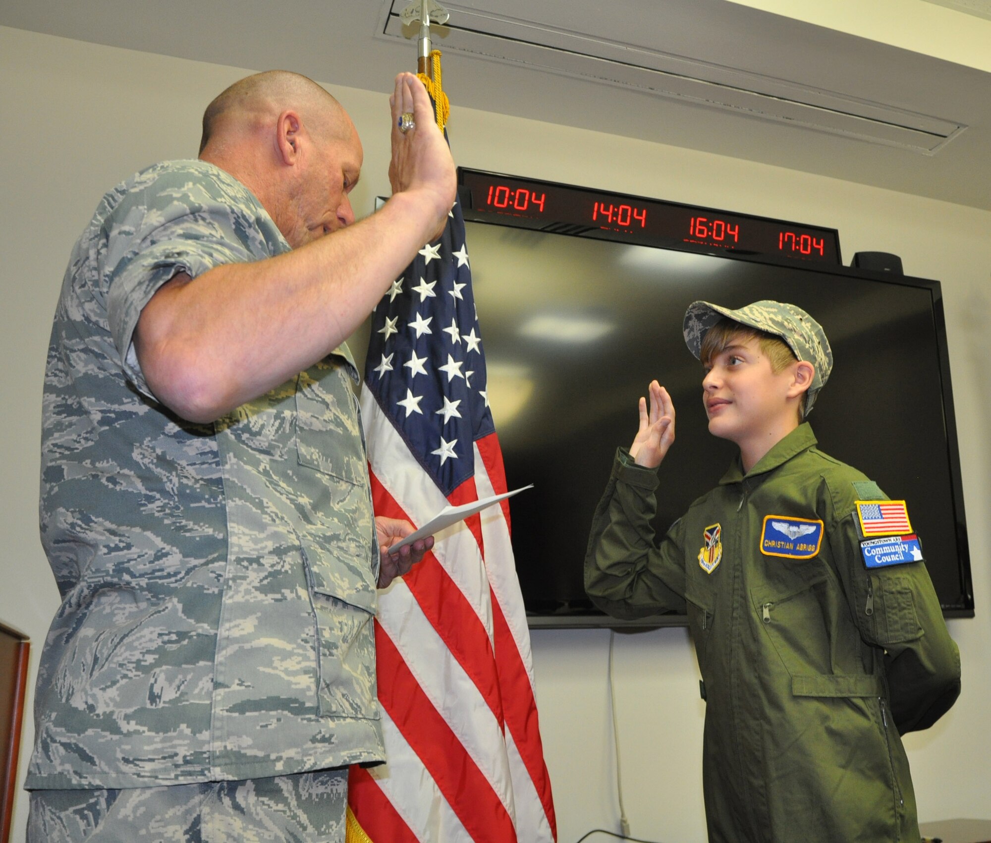 Air Force Reserve Col. David Post, commander of the 910th Maintenance Group, swears in 13-year old Christian Abrigg, of Canfield, Ohio, as an honorary second lieutenant as part of the wing's 58th Pilot for a Day (PFAD) program held here, August 27, 2014. Christian is currently receiving treatment for severe persistent asthma at Akron Children's Hospital of the Mahoning Valley. The annual program, sponsored by the Youngstown Air Reserve Base Community Council, aims to brighten the day of select children who suffer from chronic or life threatening illnesses. Select children are taxied aboard a C-130 airplane, along with many interactive base activities. U.S. Air Force Photo by Maj. Brent J. Davis.