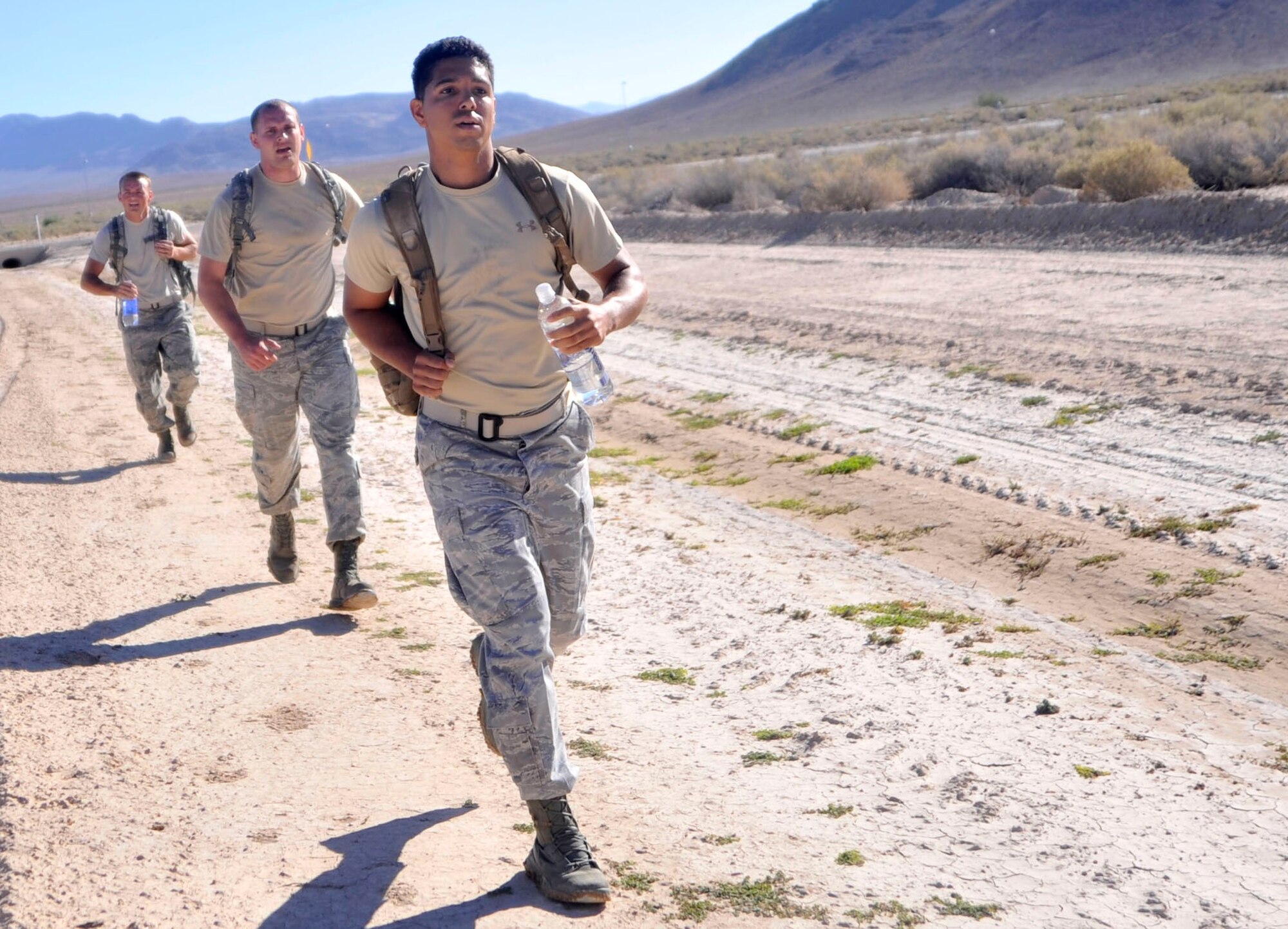 Tech. Sgt. Michael McGuire, 99th Ground Combat Training Squadron contract specialist, front, leads Staff Sgts. James Eustace and Derek Urban, 99th CONS contracting specialists during a ruck march as part of the Warrior Challenge Aug. 22, 2014, on Creech Air Force Base, Nev. This was the first Warrior Challenge hosted on Creech AFB and is part of the Life of a Warrior campaign, which takes place on both Creech and Nellis Air Force Bases, Nev. (U.S. Air Force photo by Airman 1st Class Christian Clausen/Released)