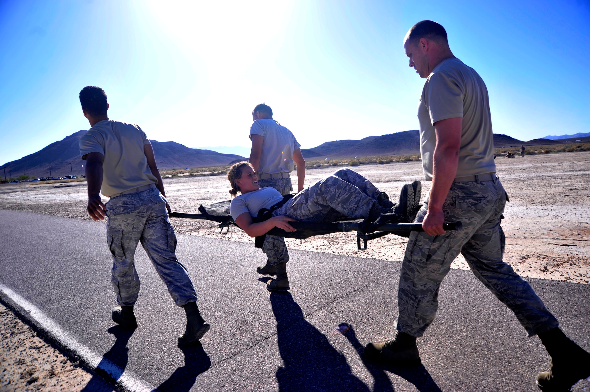 Members of the 99th Contracting Squadron carry 1st Lt. Amber Sikora, 99th CONS contracting officer, on a litter for over a quarter of a mile during the Warrior Challenge Aug. 22, 2014, at Creech Air Force Base, Nev. The Warrior Challenge included pushups, weapons assembly, Humvee pushes, litter carries, ruck marches, and at the end, participants maneuvered around "enemy combatants" to the finish line. (U.S. Air Force photo by Airman 1st Class Christian Clausen/Released)