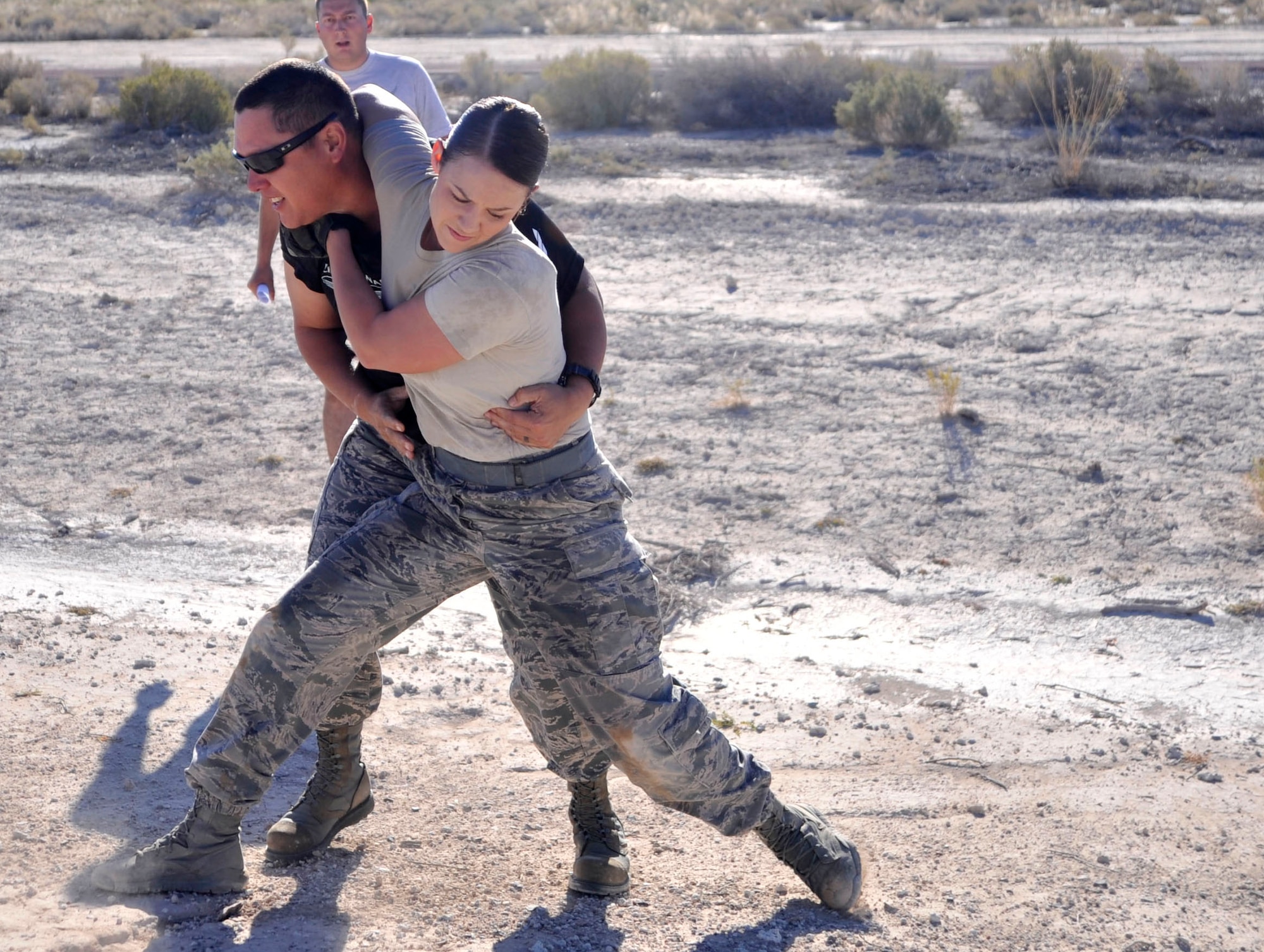 Senior Airman Grace Biro, 99th Ground Combat Training Squadron Supply journeyman, attempts to "take down" Chief Master Sgt. Brian Sato, 22nd Reconnaissance Squadron chief enlisted manager, Aug. 22, 2014, during the first ever Warrior Challenge hosted on Creech Air Force Base Nev. Sato acted as an "enemy combatant" in an attempt to prevent Biro and her team from crossing the finish line of the Warrior Challenge (U.S. Air Force photo by Airman 1st Class Christian Clausen/Released) 
