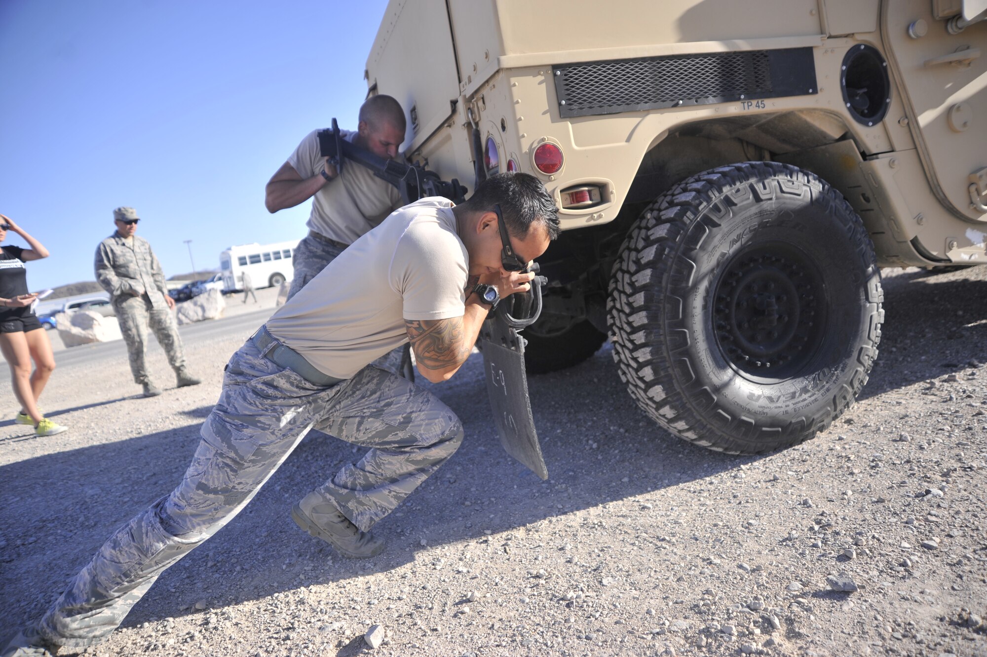 Senior Airman Carlo Mendo, 99th Ground Combat Training Squadron Supply journeyman, assists his team in pushing a Humvee across a 60 meter distance during the Warrior Challenge Aug. 22, 2014, at Creech Air Force Base, Nev. The Warrior Challenge is part of the Life of a Warrior which aims to improve the four pillars of resiliency of its participants. (U.S. Air Force photo by Airman 1st Class Christian Clausen/Released)