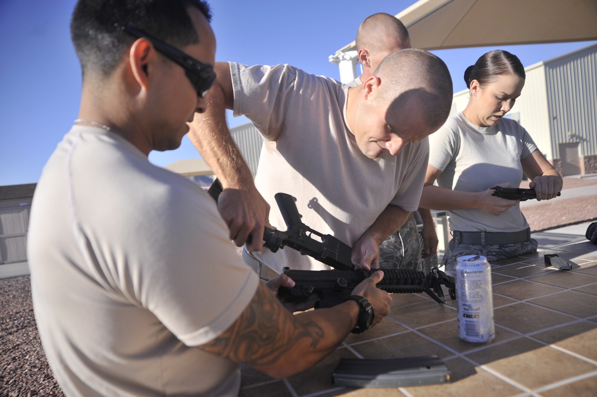 Senior Airman Carlo Mendo, 99th Ground Combat Training Squadron Supply journeyman, left, assists Staff Sgt. Brent Olson, 99th GCTS K-9 instructor, with assembling an M-4 Carbine during the Warrior Challenge Aug. 22, 2014, at Creech Air Force Base, Nev. This was the first-ever Warrior Challenge hosted on Creech AFB and is part of the Life of a Warrior campaign. (U.S. Air Force photo by Airman 1st Class Christian Clausen/Released)