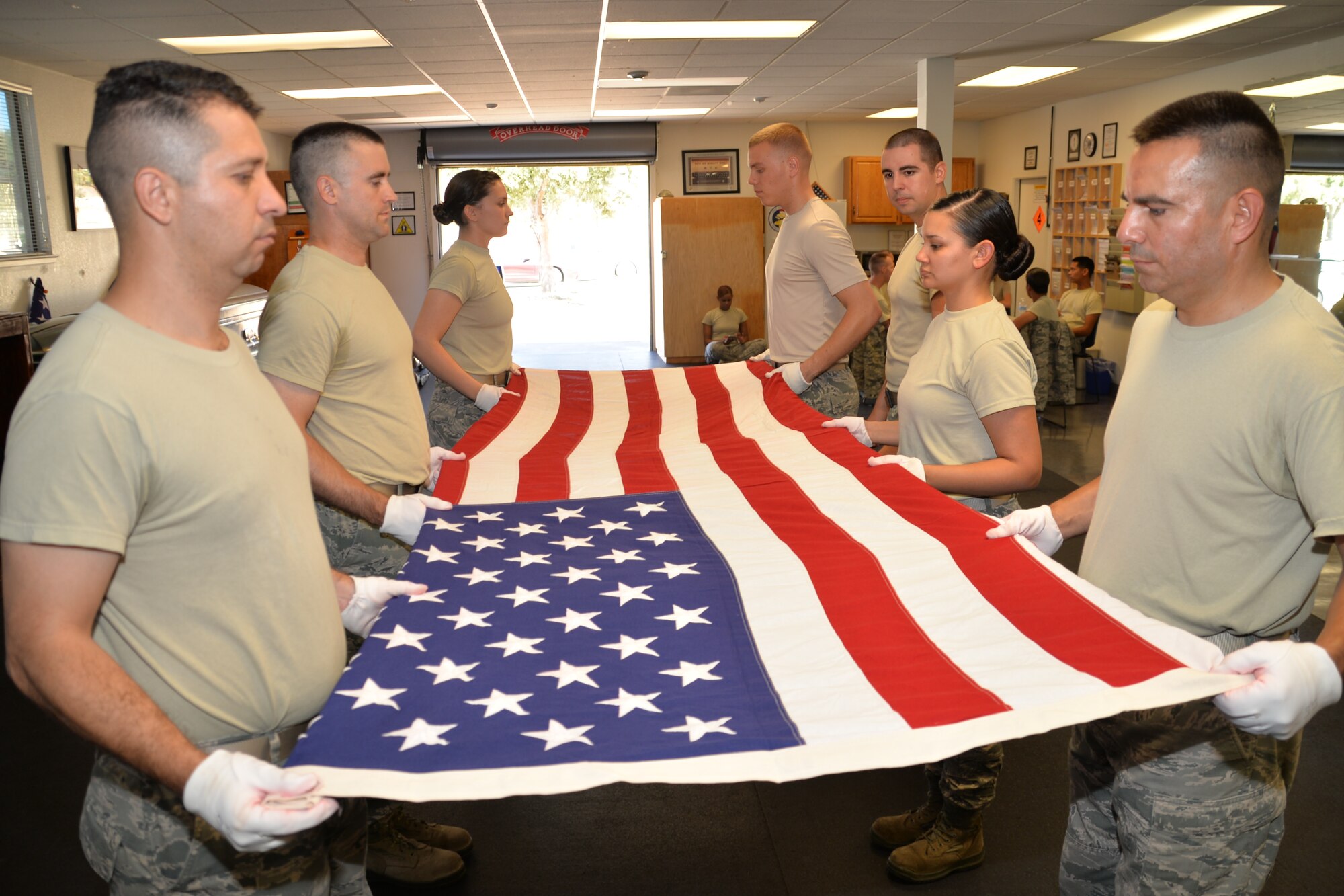 Members of the 349th Air Mobility Wing practice performing a six-man flag fold during a week-long training class with the Travis Honor Guard. This flag-folding routine is performed during an active-duty or retiree funeral. (U.S. Air Force photo/Senior Airman Bryan Swink)