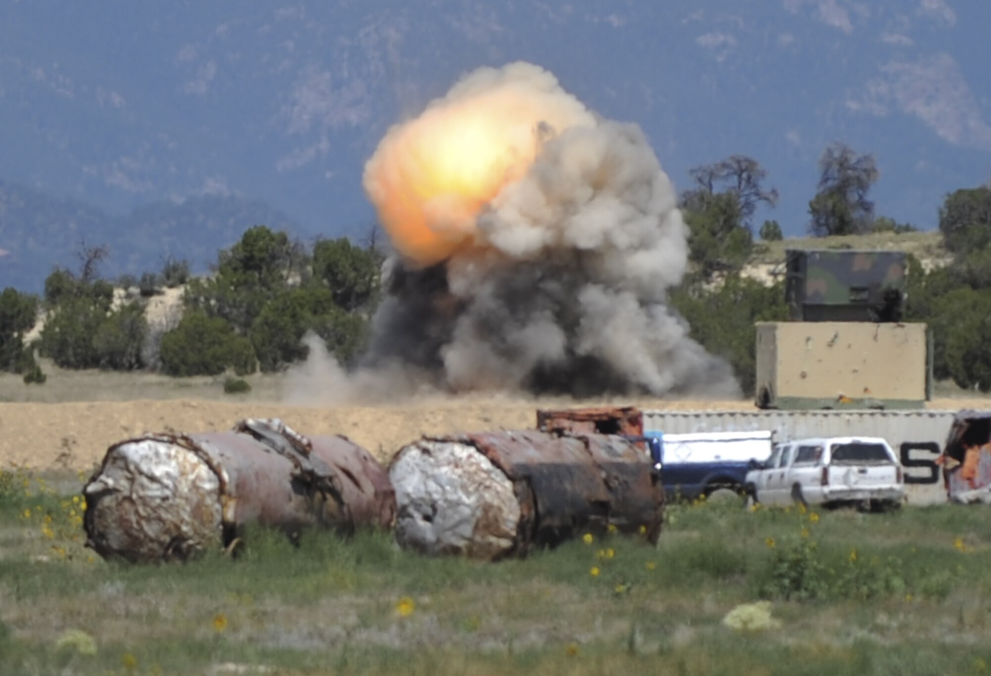 FORT CARSON, Colo. -- A cloud of fire and smoke billows up from the other side of a berm where the 21st Civil Engineer Squadron explosive ordnance disposal team used shaped charges at Fort Carson’s Airburst Range Aug. 19. The EOD team goes to the range at Fort Carson about once a month to do upgrade training and stay proficient in their skills. (U.S. Air Force photo/Staff Sgt. Jacob Morgan)