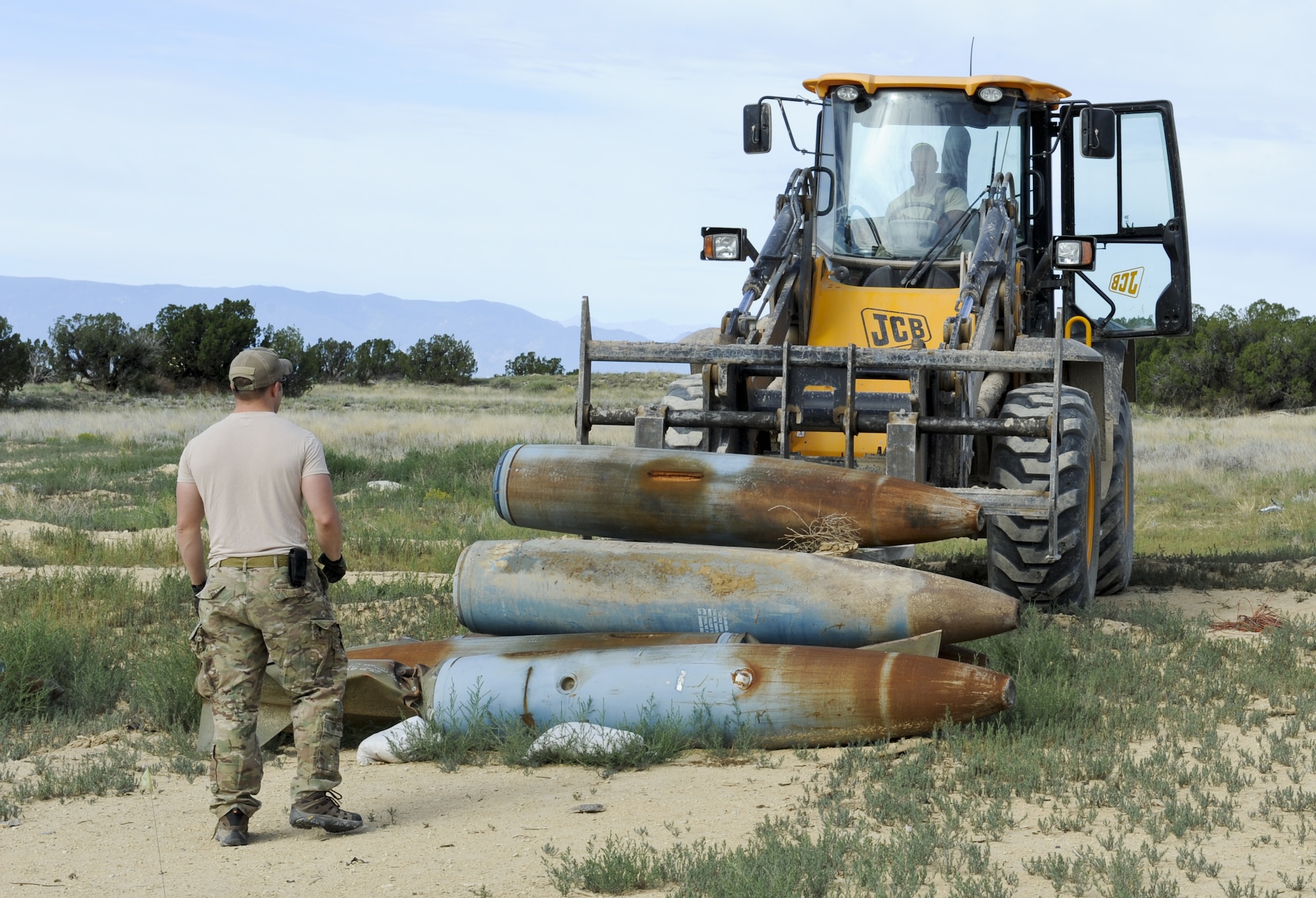 FORT CARSON, Colo. -- Senior Airman David Hartman, 21st Civil Engineer Squadron explosive ordnance disposal technician, guides a tractor carrying several BDU-50 bombs in preparation for their hands-on training at Fort Carson’s Airburst Range Aug. 19. The EOD team goes to the range at Fort Carson about once a month to do upgrade training and stay proficient in their skills. (U.S. Air Force photo/Airman 1st Class Rose Gudex)