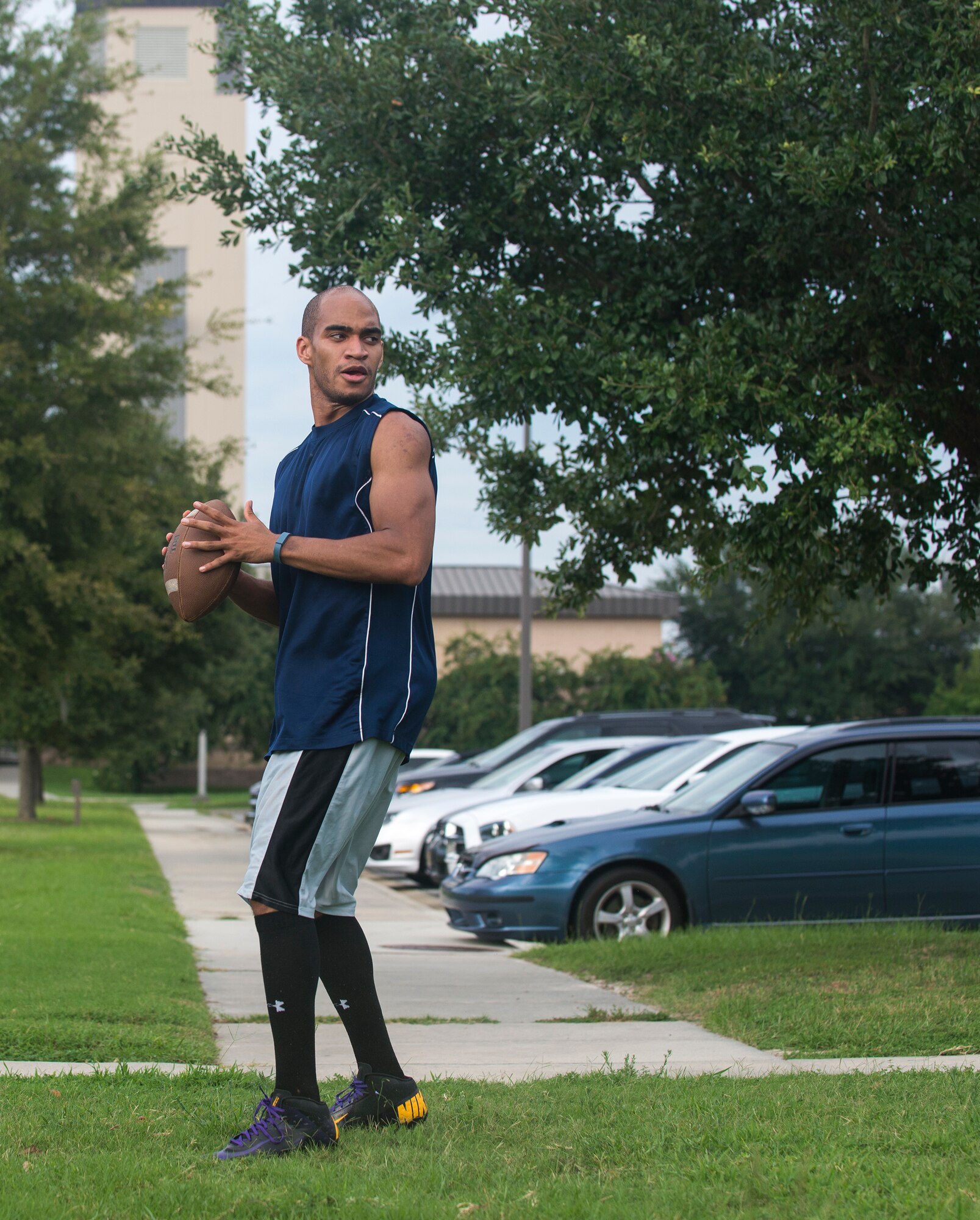 U.S. Air Force Senior Airman Marc Lawson, 23d Wing Command Post  emergency action controller, prepares to pass the ball to a teammate during flag football practice at Moody Air Force Base, Ga., Aug. 27, 2014. The team, comprised of members from the Force Support and Comptroller Squadrons, as well as  Wing Staff Agencies, ran through plays to prepare for the upcoming season. (U.S. Air Force photo by Airman 1st Class Sandra Marrero/Released)
