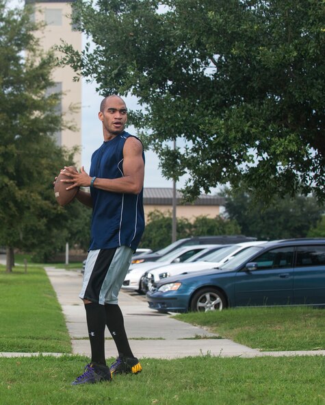 U.S. Air Force Senior Airman Marc Lawson, 23d Wing Command Post  emergency action controller, prepares to pass the ball to a teammate during flag football practice at Moody Air Force Base, Ga., Aug. 27, 2014. The team, comprised of members from the Force Support and Comptroller Squadrons, as well as  Wing Staff Agencies, ran through plays to prepare for the upcoming season. (U.S. Air Force photo by Airman 1st Class Sandra Marrero/Released)
