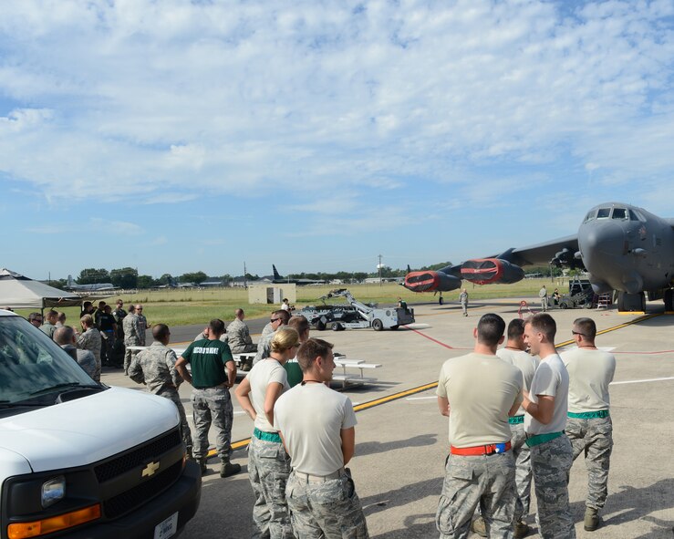 Spectators watch Airmen from the 2nd Aircraft Maintenance Squadron load munitions onto a B-52H Stratofortress during the 2014 Global Strike Challenge on Barksdale Air Force Base, La., Aug. 27. The purpose of the challenge is to recognize outstanding Air Force Global Strike Command personnel and teams and improve combat capabilities through competition and community crosstalk. (U.S. Air Force photo/Senior Airman Benjamin Gonsier)