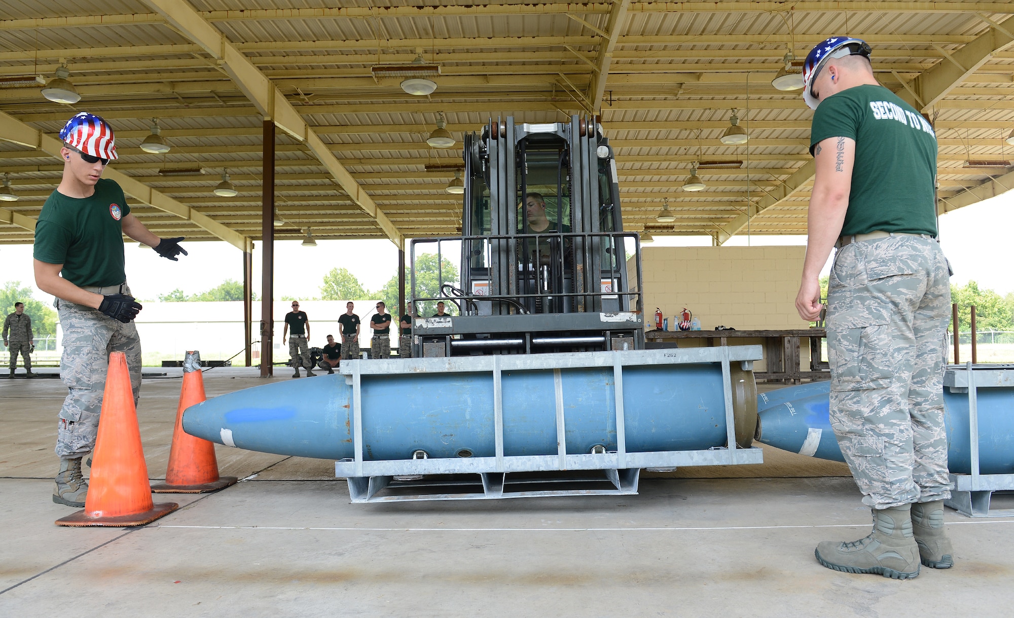 Senior Airman Gregory Quailer, left, 2nd Munitions Squadron bomb build team, directs Tech. Sgt. Jeremy Burney, center, 707th Maintenance Squadron, where to place a munition during the 2014 Global Strike Challenge on Barksdale Air Force Base, La., Aug. 26. In this challenge, the Airmen had to precisely place a bomb in a designated area without touching the munition next to it. (U.S. Air Force photo/Senior Airman Benjamin Gonsier)