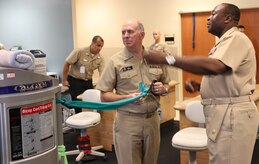 Naval Health Clinic Charleston commanding officer Capt. Marvin Jones (right), watches as Vice Adm. Matthew Nathan, U.S. Navy Surgeon General and Bureau of Medicine and Surgery chief, performs a theraband exercise at the NHCC Physical Therapy department, Aug. 27, 2014, at Joint Base Charleston, S.C. During his visit, Nathan met with staff members to discuss U.S. Navy health care, medical readiness and joint service opportunities, had lunch with NHCC's civilians and Sailors of the Year, and held an “All Hands” call. (U.S. Air Force photo/Seaman Cody Meeks) 

