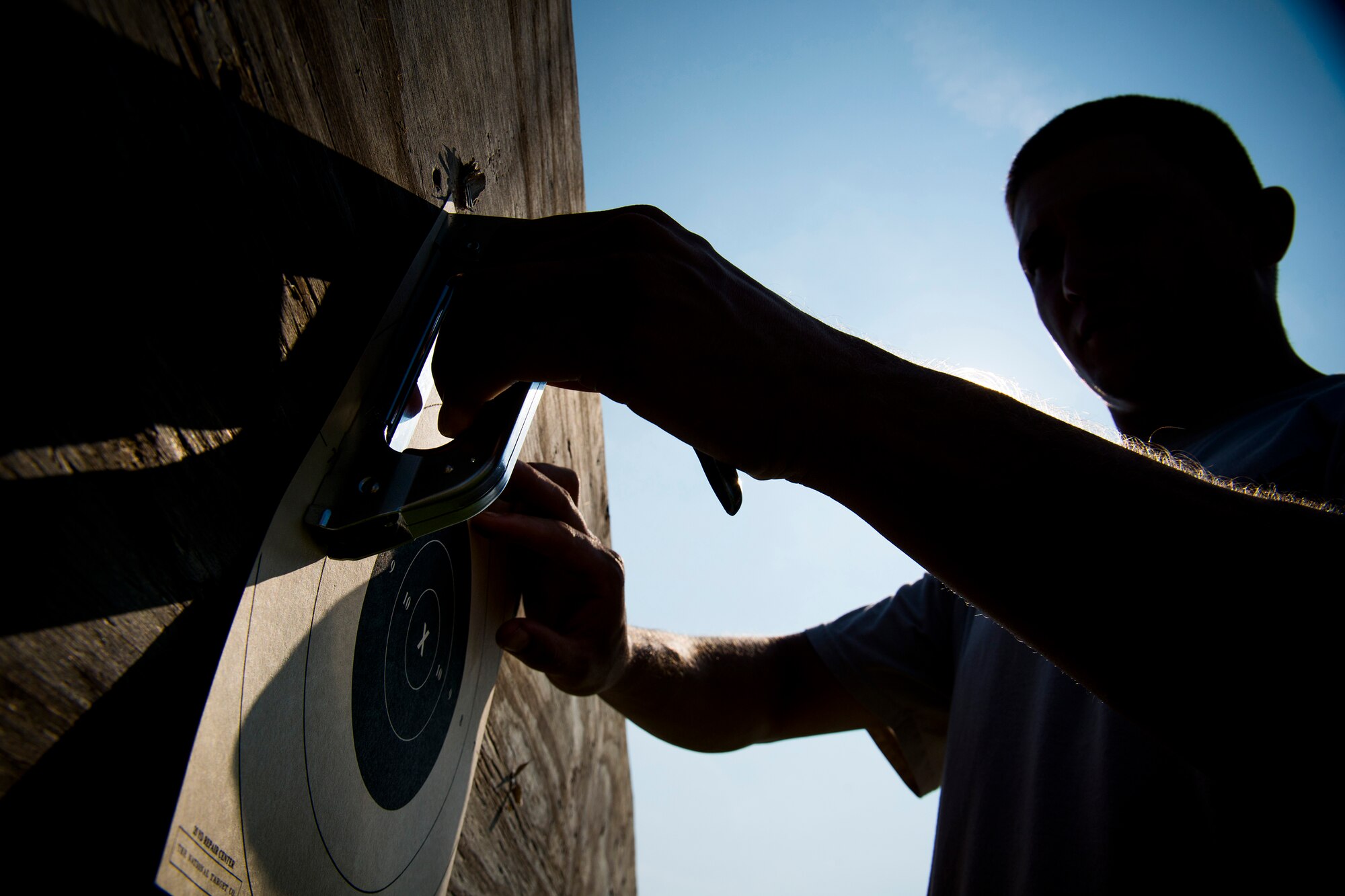 U.S. Air Force Staff Sgt. Jeremiah Jackson, 23d Equipment Maintenance Squadron aircraft metals technology craftsman, attaches a target to a shooting post in Valdosta, Ga., Aug. 15, 2014. Jackson tries to practice shooting three times a week and says he shoots about 300 rounds during a practice session. (U.S. Air Force photo by Staff Sgt. Jamal D. Sutter/Released) 