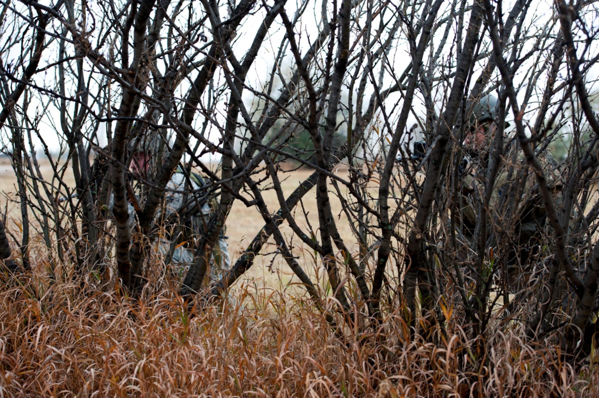 Security Forces Airmen demonstrate the effectiveness of various camouflage patterns at Minot Air Force Base, N.D. The Airman on the right is wearing an OCP (MultiCam) uniform, where the Airman on the left is wearing ABUs. (U.S. Air Force Courtesy Photo)