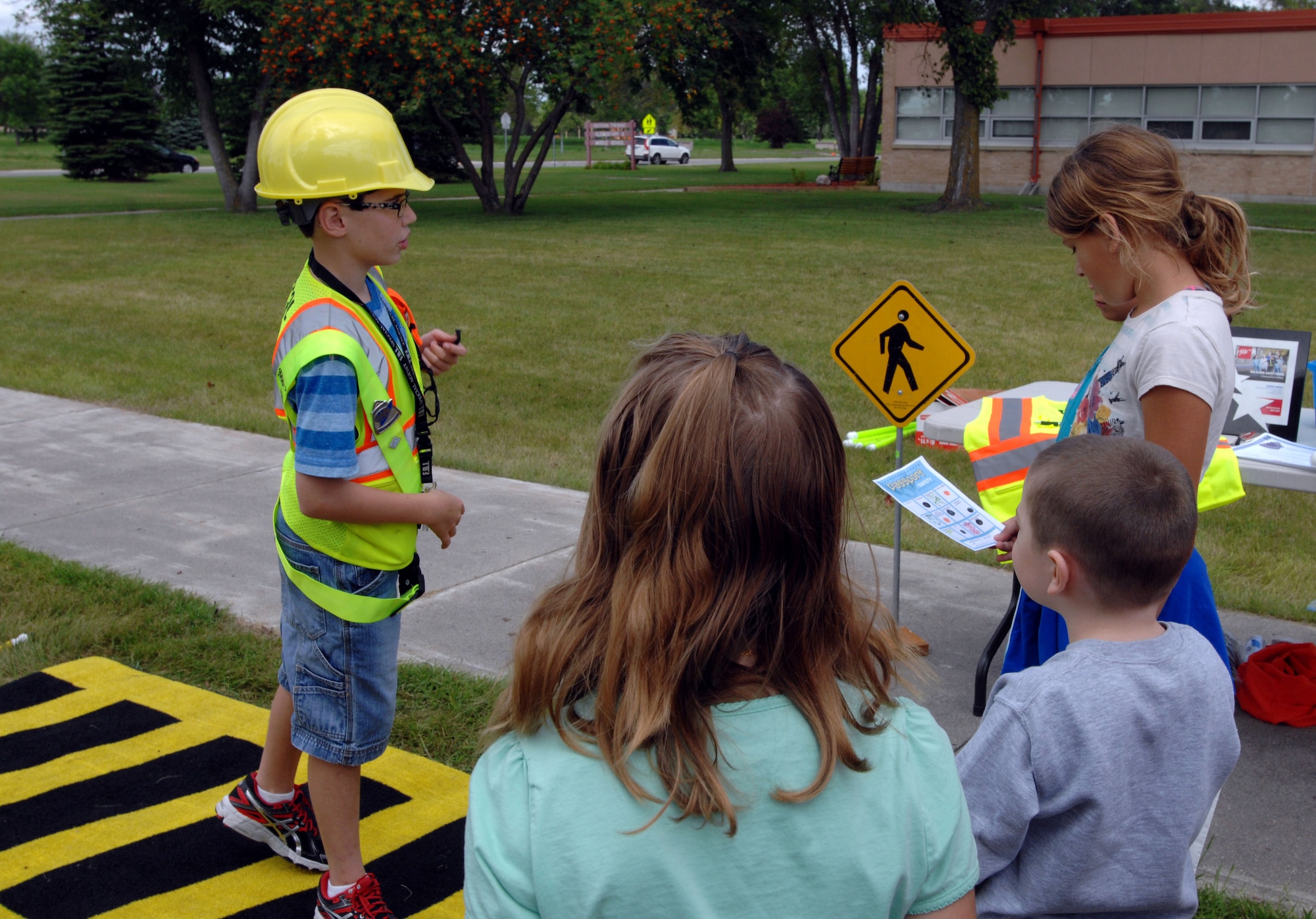 Camden Larsen, 12, an incoming 6th-grade student at Schroeder Middle School in the city of Grand Forks, gives a crosswalk safety demonstration for children who will be walking to school during the coming school year at the Kids’ Passport to Safety event at Nathan F. Twining Elementary and Middle School on Grand Forks Air Force Base, N.D., Aug. 26, 2014. There were also several information tables at the event that offered the school traffic plan for when school begins, as well as a carpooling directory, new school security guidelines, and supervision options for before and after school. (U.S. Air Force photo/Staff Sgt. Susan L. Davis)