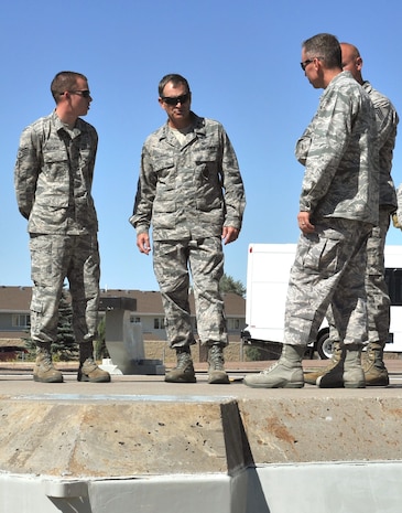 Maj. Gen. H.D. Polumbo, 9th Air Force commander (center), listens Aug. 26 as Staff Sgt. Nathan McKenzie, 341st Maintenance Operations Squadron missile maintenance instructor (left), and Col. Tom Wilcox, 341st Missile Wing commander, explain the mechanics of the launcher-closure door at Malmtrom Air Force Base’s T-9 launch facility maintenance trainer. Polumbo was at Malmstrom  AFB, Mont., Aug. 25-27 to visit the 819th RED HORSE Squadron and tour the 341st Missile Wing’s nuclear mission. (U.S. Air Force photo/John Turner)