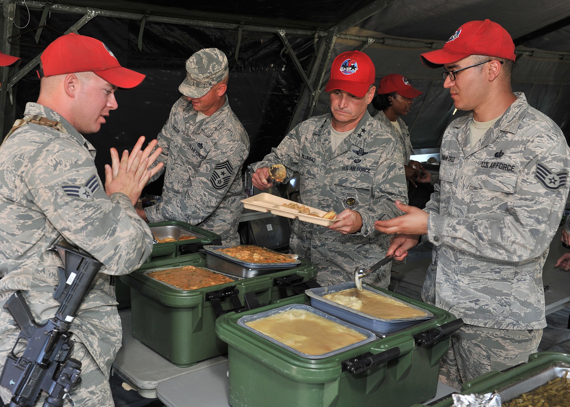 Maj. Gen. H.D. Polumbo, 9th Air Force commander, center, serves dinner to 819th RED HORSE Squadron Airmen Aug. 26 during the squadron’s phase II field training exercise. Polumbo was at Malmstrom Air Force Base, Mont., Aug. 25-27 to visit the 819th RHS and tour the 341st Missile Wing’s nuclear mission. (U.S. Air Force photo/John Turner)