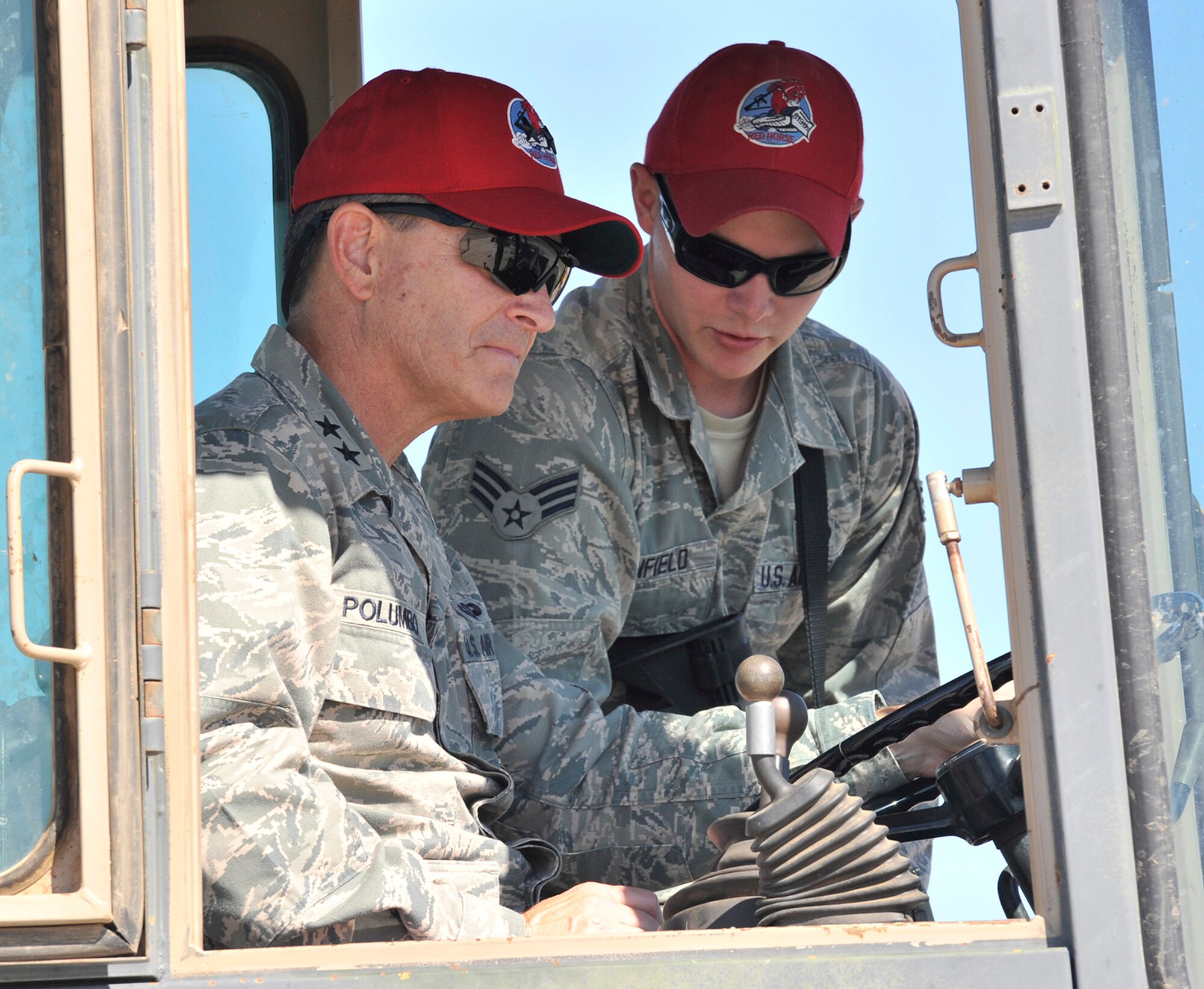 Senior Airman Devon Canfield, 819th RED HORSE Squadron heavy equipment operator, assists as Maj. Gen. H.D. Polumbo, 9th Air Force commander, operates a front end loader Aug. 26 at the squadron’s heavy equipment training area. Polumbo was at Malmstrom Air Force Base, Mont., Aug. 25-27 to visit the 819th RHS and tour the 341st Missile Wing’s nuclear mission. (U.S. Air Force photo/John Turner)