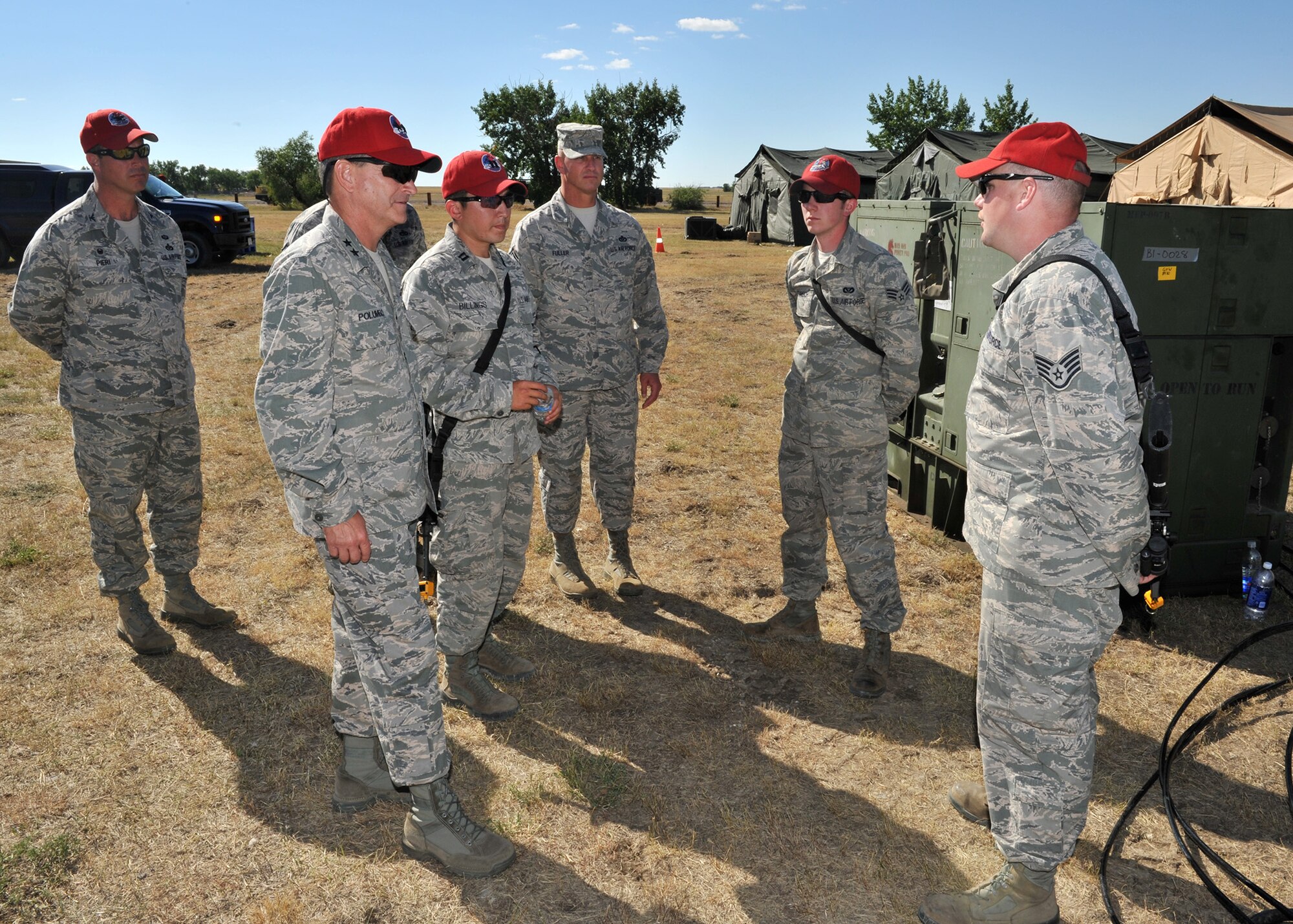 Maj. Gen. H.D. Polumbo, 9th Air Force commander, is briefed by Staff Sgt. Dennis Sparks (right) and Senior Airman Nathan Stanisch, 819th RED HORSE Squadron electrical power production team members, Aug. 26 at the 819th RHS’s phase II field training exercise. Col. Ron Pieri, 819th RHS commander, Capt. Peter Billings, 819th RHS logistics flight commander, and Chief Master Sgt. Scott Fuller, 9th Air Force command chief, look on. Polumbo was at Malmstrom  Air Force Base, Mont., Aug. 25-27 to visit the 819th RHS and tour the 341st Missile Wing’s nuclear mission. (U.S. Air Force photo/John Turner)