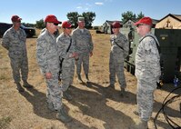 Maj. Gen. H.D. Polumbo, 9th Air Force commander, is briefed by Staff Sgt. Dennis Sparks (right) and Senior Airman Nathan Stanisch, 819th RED HORSE Squadron electrical power production team members, Aug. 26 at the 819th RHS’s phase II field training exercise. Col. Ron Pieri, 819th RHS commander, Capt. Peter Billings, 819th RHS logistics flight commander, and Chief Master Sgt. Scott Fuller, 9th Air Force command chief, look on. Polumbo was at Malmstrom  Air Force Base, Mont., Aug. 25-27 to visit the 819th RHS and tour the 341st Missile Wing’s nuclear mission. (U.S. Air Force photo/John Turner)
