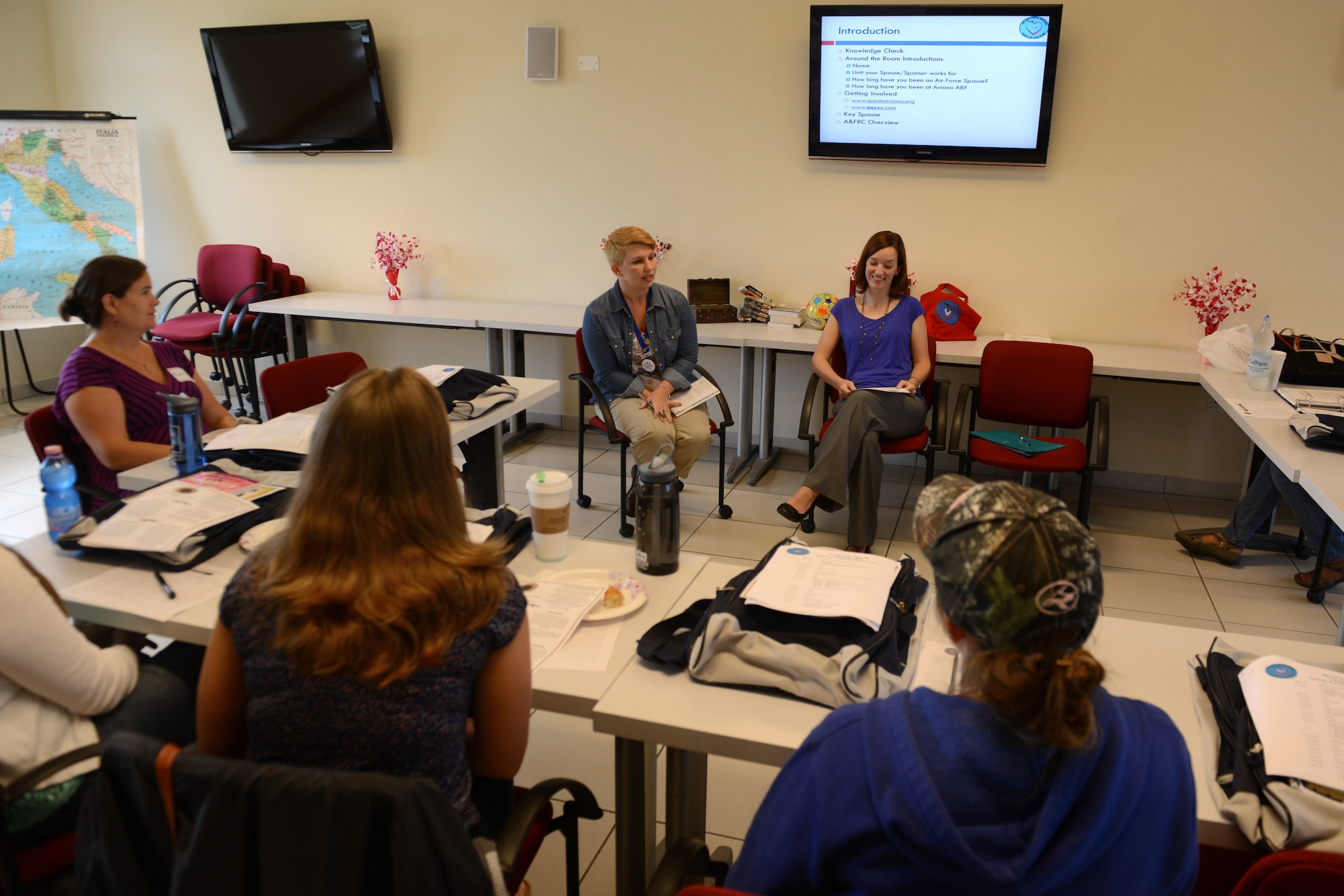 Jerri Helton, Aviano Officer and Civilian Spouse Club, and Kerri Schoonmaker, Aviano Club for Enlisted Spouses, talk to a group of spouses at “Heartlink,”Aug. 28, 2014, at Aviano Air Base, Italy. Both spouses informed the group that they were dedicated to supporting them with an outlet to interact, help and communicate through volunteerism and charitable services. “Heartlink” is held quarterly and the next class is scheduled for Nov. 6. (U.S. Air Force photo/Airman 1st Class Ryan Conroy) 
