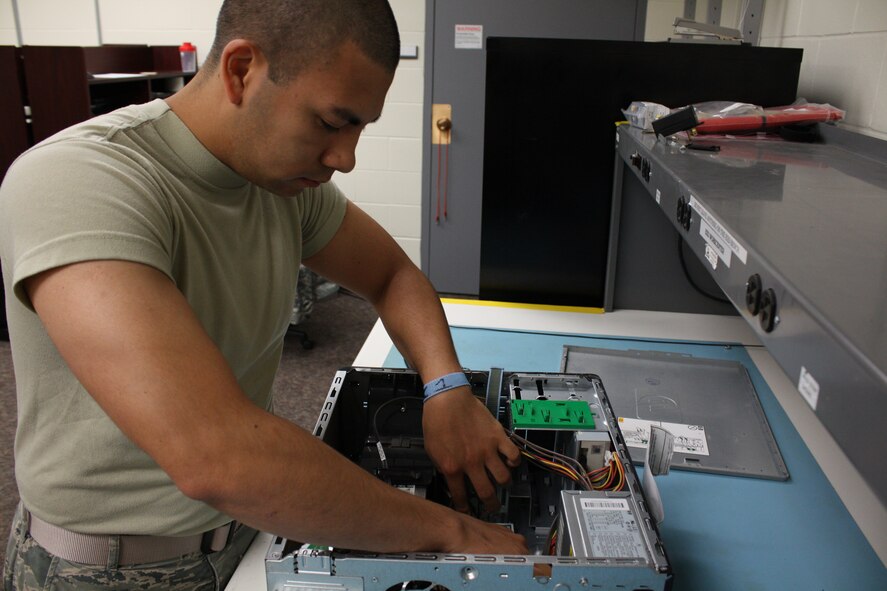 Airman 1st Class Ivan Najera, 5th Communications Squadron client systems technician, ensures electronic components are properly seated on a Minot Air Force Base network computer, Aug. 20. As a CST, Najera responds to trouble tickets generated through the Enterprise Service Desk. Starting Sept. 22 ESD  will also include the virtual ESD. (U.S. Air Force photo/Capt. Jeff M. Nagan) 