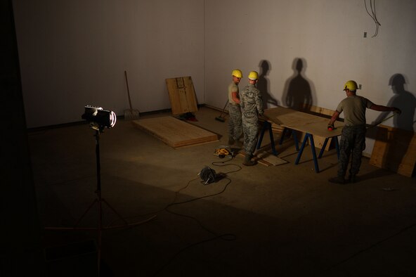 Members of the 52nd Civil Engineer Squadron cut wood at a construction site inside the Skelton Memorial Fitness Center Aug. 26, 2014. The construction included renovation of old racquetball courts to create a new Combat Fitness gym area. (U.S. Air Force photo by Senior Airman Gustavo Castillo/Released) 