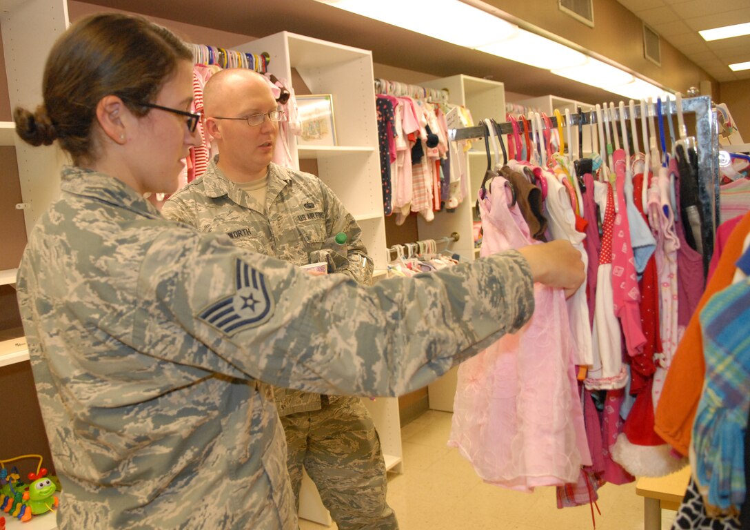 Staff Sgt. Kaitlyn Salvatore, 461st Maintenance Group training manager and Staff Sgt. Daniel Letchworth, 78th Communications Directorate radio maintenance, look at clothes for their daughter at the Airman’s attic grand opening, August 25, 2014. The volunteer-run facility, which relocated to the old Outdoor Recreation Center in Bldg. 914, provides E-1s to E-5s and O-1s and O-2s with free items donated by the community. Those items include things such as clothing, furniture, small appliances and electronics. New hours are Tuesdays from 9 a.m. to noon; Thursdays from 3 to 6 p.m., with the last Saturday of each month open as needed. (U.S. Air Force photo by Misuzu Allen)


