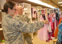 Staff Sgt. Kaitlyn Salvatore, 461st Maintenance Group training manager and Staff Sgt. Daniel Letchworth, 78th Communications Directorate radio maintenance, look at clothes for their daughter at the Airman’s attic grand opening, August 25, 2014. The volunteer-run facility, which relocated to the old Outdoor Recreation Center in Bldg. 914, provides E-1s to E-5s and O-1s and O-2s with free items donated by the community. Those items include things such as clothing, furniture, small appliances and electronics. New hours are Tuesdays from 9 a.m. to noon; Thursdays from 3 to 6 p.m., with the last Saturday of each month open as needed. (U.S. Air Force photo by Misuzu Allen)

