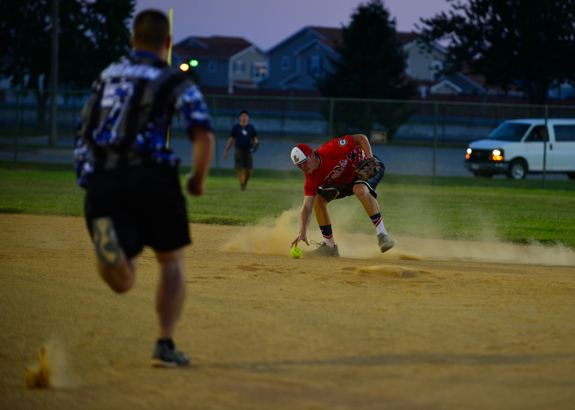 James Keener, 373d Training Squadron shortstop, fields a ground ball while Andrew Bowen, 436th Security Forces Squadron right fielder, sprints towards second base during the intramural softball championship Aug. 25, 2014, at the softball field on Dover Air Force Base, Del. The 373d TRS fell short in both championship games 10-9 and 14-8. (U.S. Air Force photo/Airman 1st Class William Johnson)