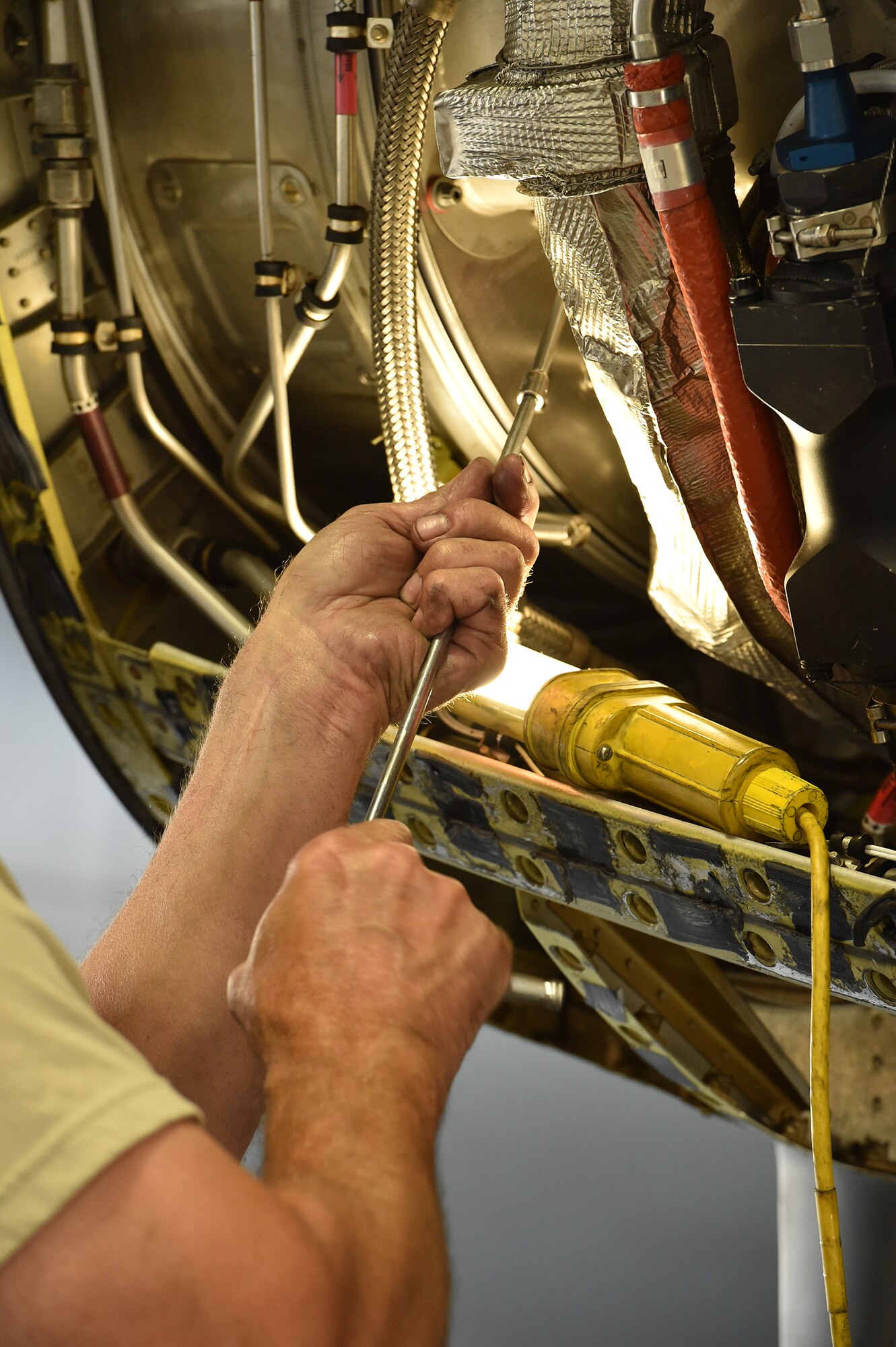 An Airman with the 910th Maintenance Squadron fastens a bolt in a C-130H Hercules aircraft engine compartment here, Aug. 25, during an isochronal inspection. Each Youngstown C-130 undergoes an isochronal inspection every 540 days. 910th Maintainers now perform the inspections using a new, $1.5 million dock stand system designed to increase efficiency and safety for workers. YARS is the first installation in Air Force Reserve Command to acquire the system beyond its prototype phase. U.S. Air Force photo/Eric M. White.