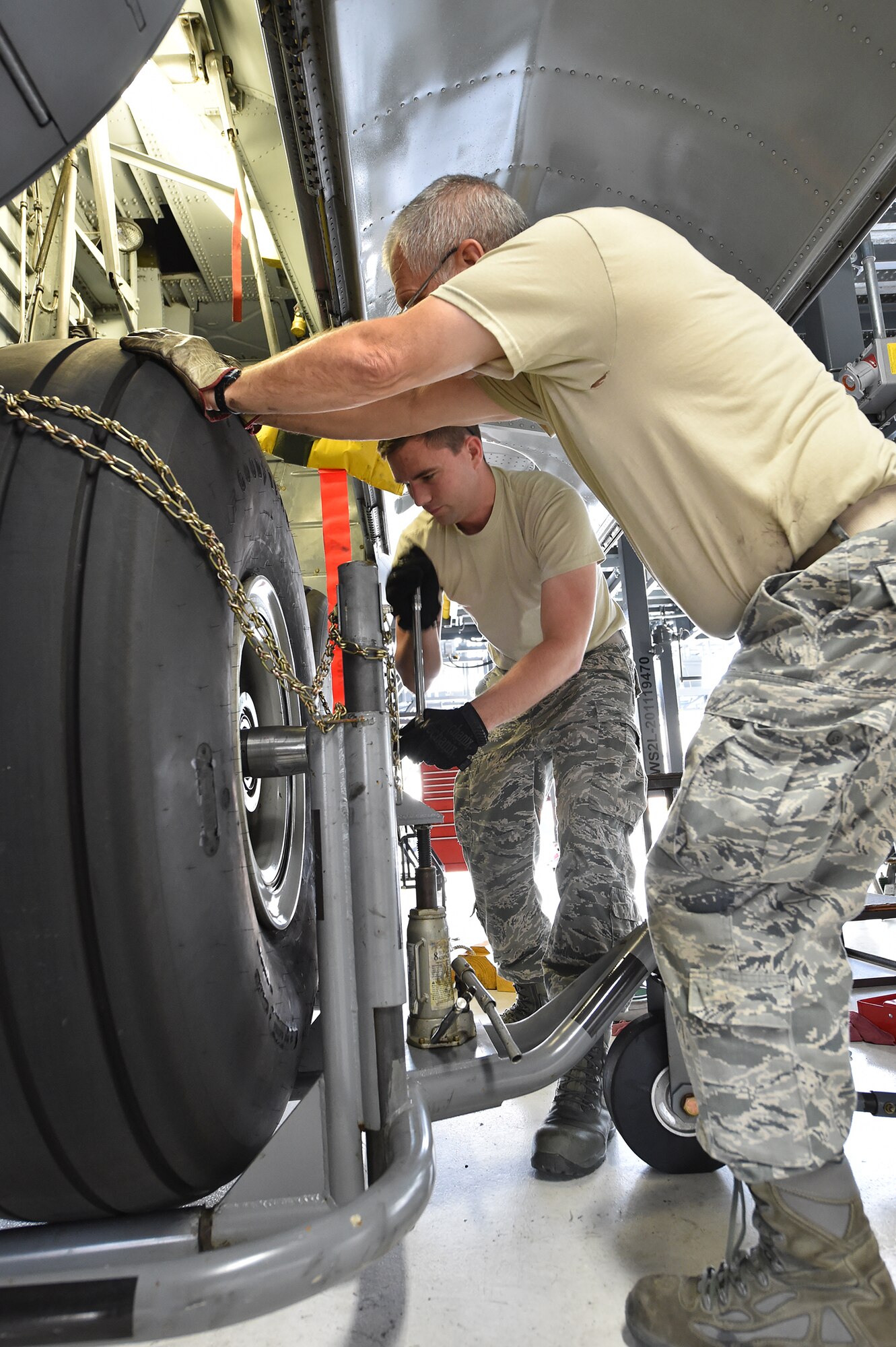Master Sgt. Gary Bradshaw, a 910th Maintenance Squadron aerospace maintenance craftsman, and Senior Airmen Daniel Clegg, a 910th Maintenance Squadron aerospace maintenance journeymen, change a tire on a C-130H Hercules aircraft during an isochronal inspection here, Aug. 25. Each Youngstown C-130 undergoes an isochronal inspection every 540 days. 910th Maintainers now perform the inspections using a new, $1.5 million dock stand system designed to increase efficiency and safety for workers. YARS is the first installation in Air Force Reserve Command to acquire the system beyond its prototype phase. U.S. Air Force photo/Eric M. White.