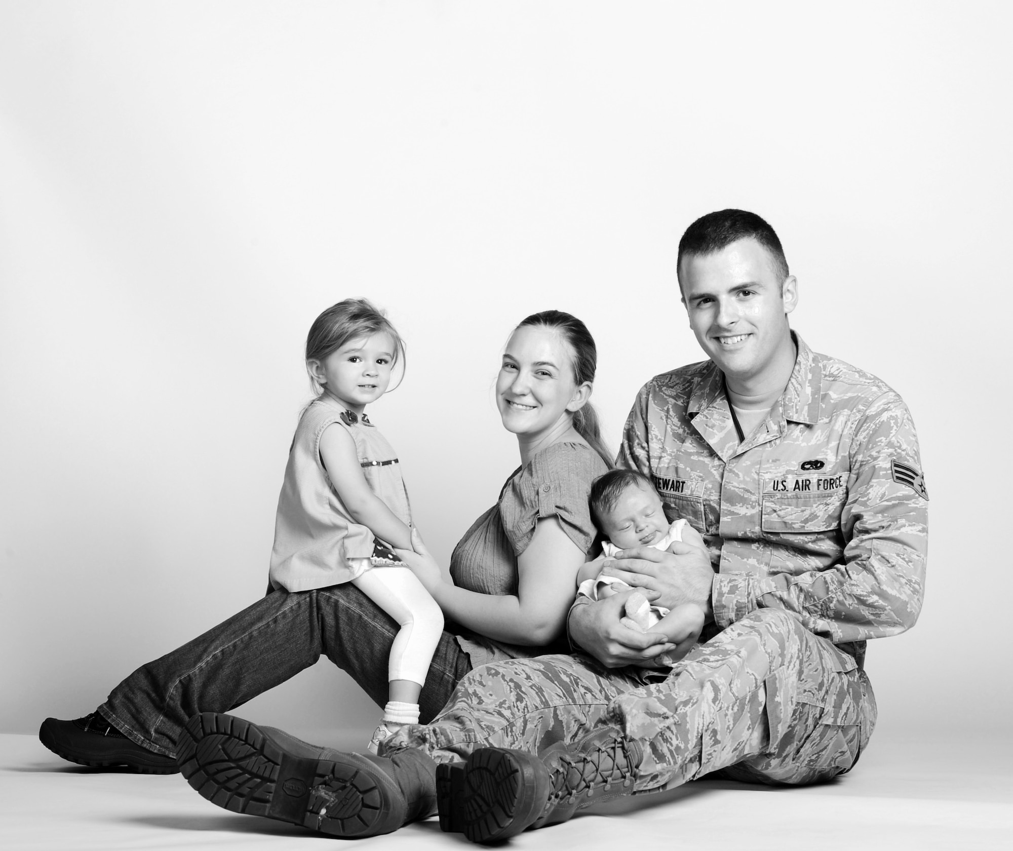 Senior Airman Paul Stewart, 509th Maintenance Squadron low observable structural maintainer, and his wife Lindsey, pose with their daughters Anna (left), and Emily (right). On July 20, 2014, Stewart delivered his and his wife's second daughter, Emily, when they were unable to make it to the hospital in time. (U.S. Air Force photo by Airman 1st Class Joel Pfiester/Released) 