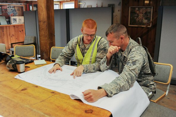 Senior Airman Daniel Brooks (left), and Senior Airman Abe Hilbers, engineer assistants for the 123rd Civil Engineer Squadron, read blue prints for new construction at Camp William Hinds Boy Scout camp in Raymond, Maine on June 9, 2014. About 30 Airmen from the 123rd Airlift Wing went to Maine for its annual deployment for training from June 1-15 to help renovate camp facilities for the Boy Scouts of America. (Courtesy Photo)