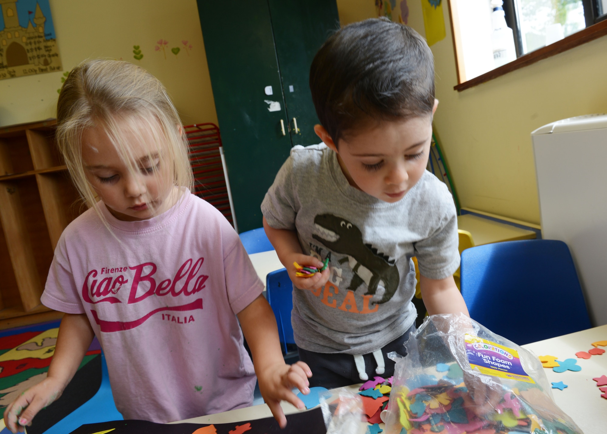 Mirabelle Heiser and Marshall Lambert play with fun foam shapes during arts and crafts time, Aug. 25, 2014, at the Aviano Co-op Care program at Aviano Air Base, Italy. The Co-op is open from 9 a.m. to 12 p.m. from Monday to Friday to allow parents to run errands or study for school. (U.S. Air Force photo/Airman 1st Class Ryan Conroy) 