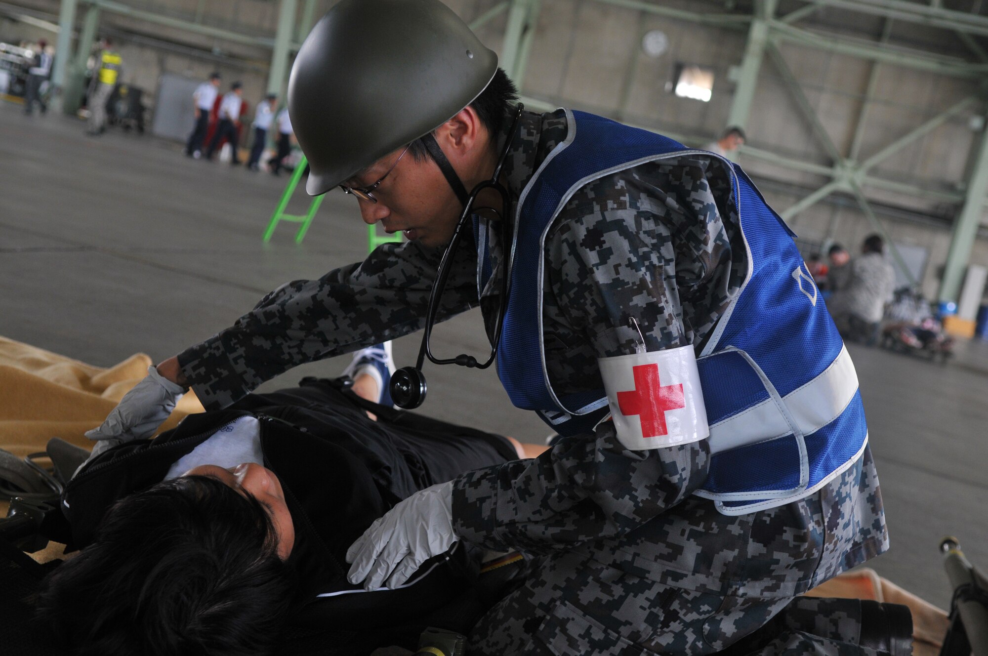 A Japan Air Self-Defense Force medic tends to a simulated wounded victim during a joint bilateral Major Accident Response Exercise at Misawa Air Base, Japan Aug. 22, 2014. JASDF and U.S. military emergency personnel responded to the accident’s scene and provided medical care to 100 simulated victims. (U.S. Air Force photo by Senior Airman Jose L. Hernandez-Domitilo)