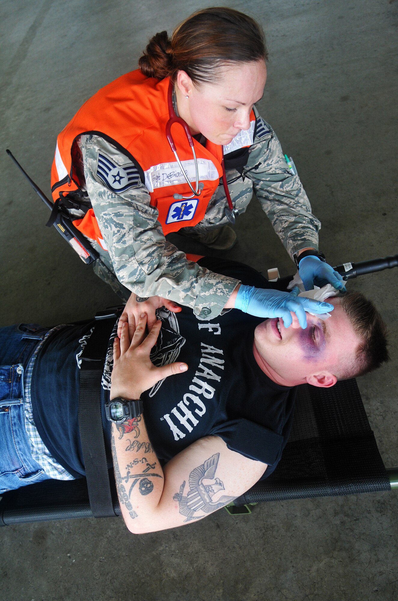 U.S. Air Force Staff Sgt. Krystle Debiase, 35th Medical Operations Squadron medical technician, simulates applying a medical disinfectant on U.S. Navy Seaman Howard Gates, Naval Air Facility security member, during a joint bilateral Major Accident Response Exercise at Misawa Air Base, Japan Aug. 22, 2014. Emergency personnel provided as much medical care as possible before transporting the victims to the hospital, just as they would in a real-world situation. (U.S. Air Force photo by Senior Airman Jose L. Hernandez-Domitilo)